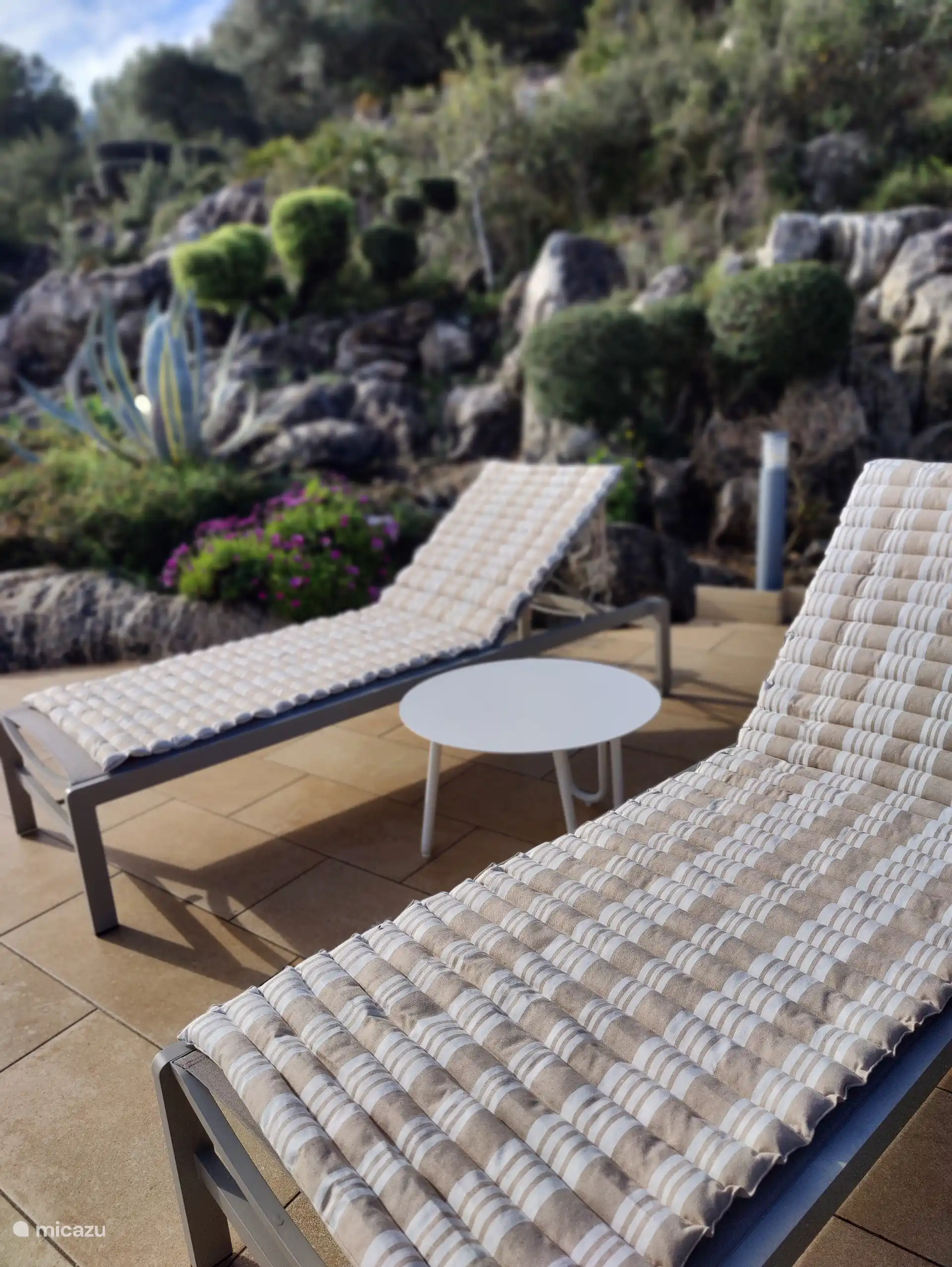 Inviting sunbeds - with parasol - by the pool.
