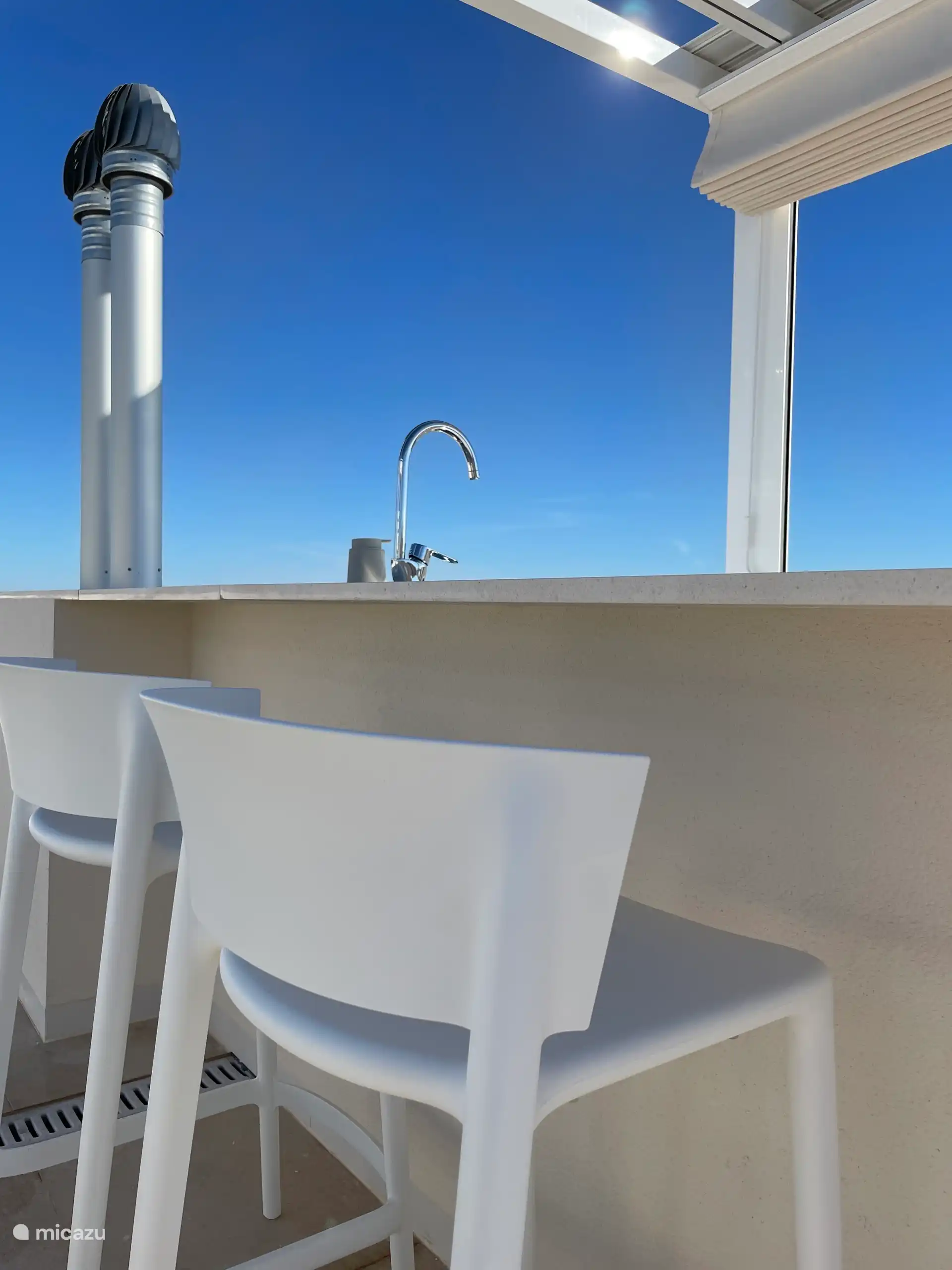 Cocina al aire libre con asientos. Un aperitivo con la mejor vista del lago rosa.