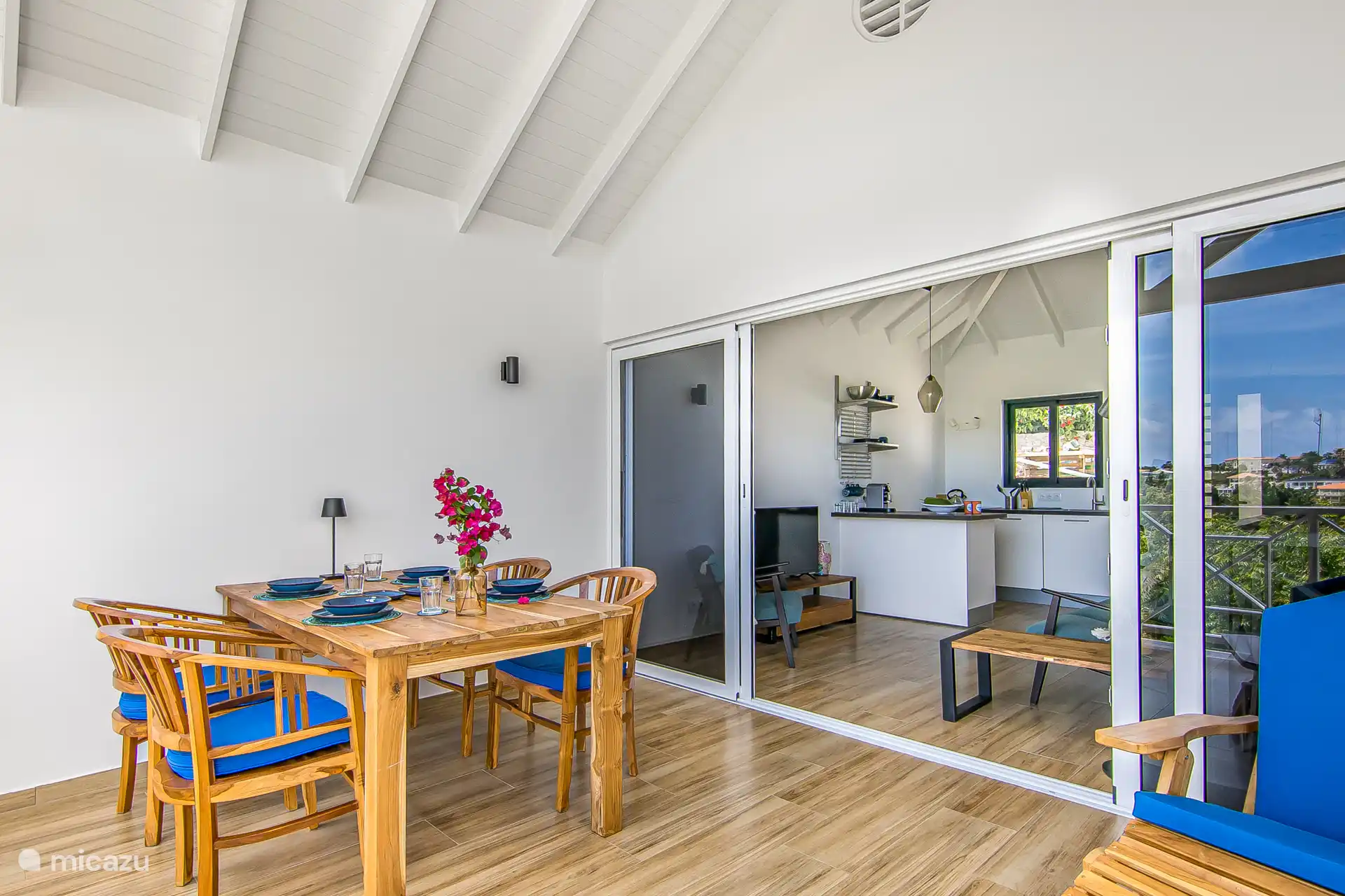 Woonkamer met schuifpui naar terras met eettafel.