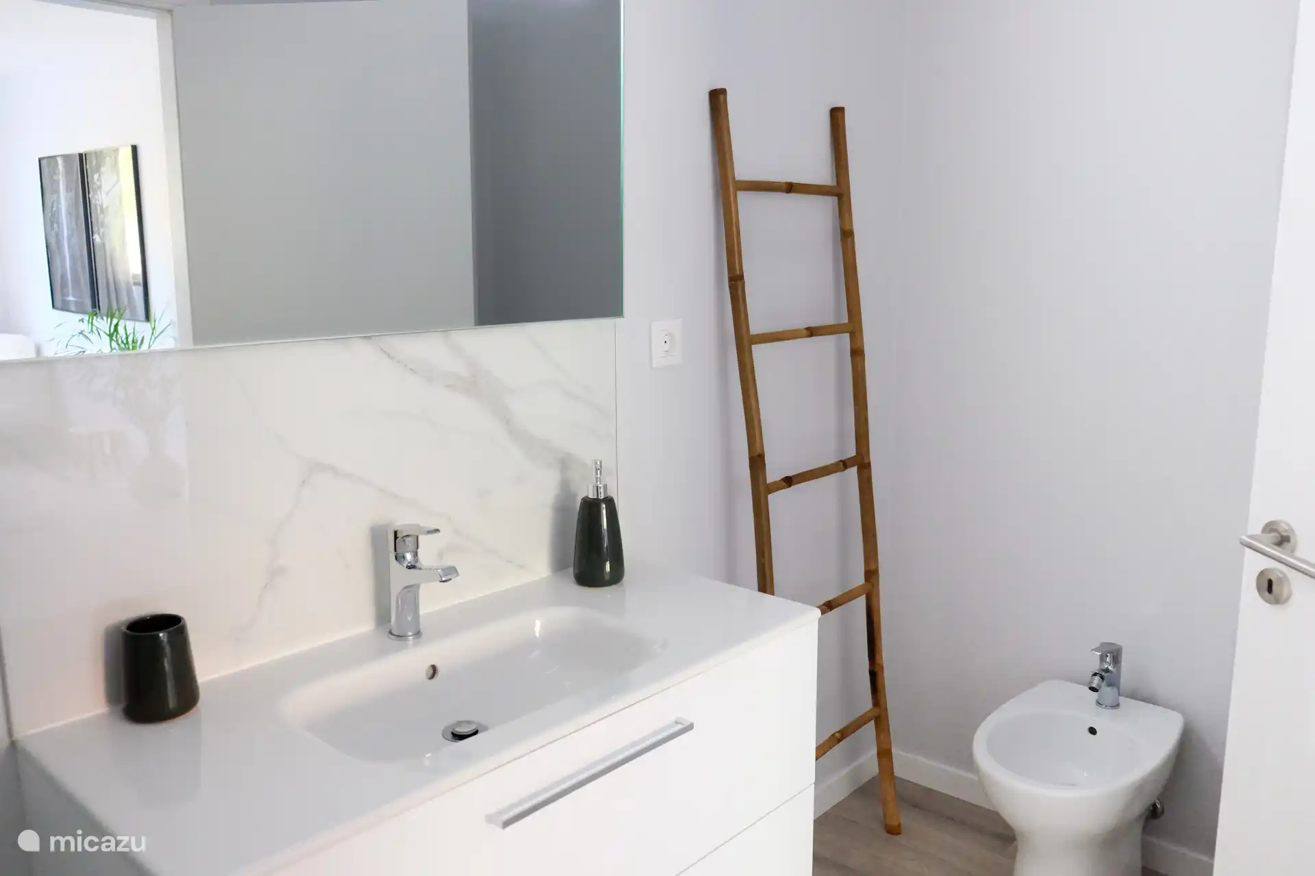 Direkt an das Hauptschlafzimmer angeschlossen ist ein eigenes Badezimmer mit WC, Bidet, Dusche und Waschbecken mit beheiztem Spiegel. So kannst du nach dem Duschen noch ganz einfach alles im Spiegel sehen.