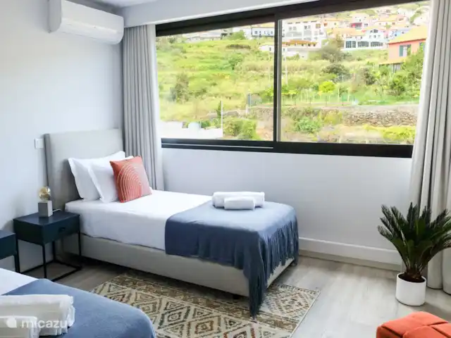 Appartement familial à Madère | Portugal, Madère, Machico - appartement La troisième chambre dispose de deux lits simples de 90 cm de large et 200 cm de long. Également dans cette chambre, vous avez la climatisation, une connexion directe avec la nature et des rideaux aveuglants.