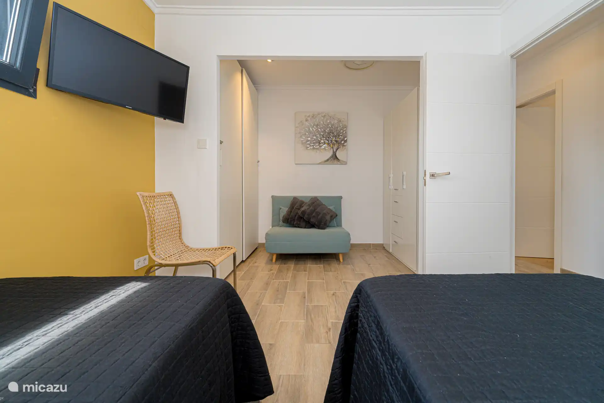 Slaapkamer met 2 enkele bedden, inbouwkasten en een slaapbank voor 1 persoon.