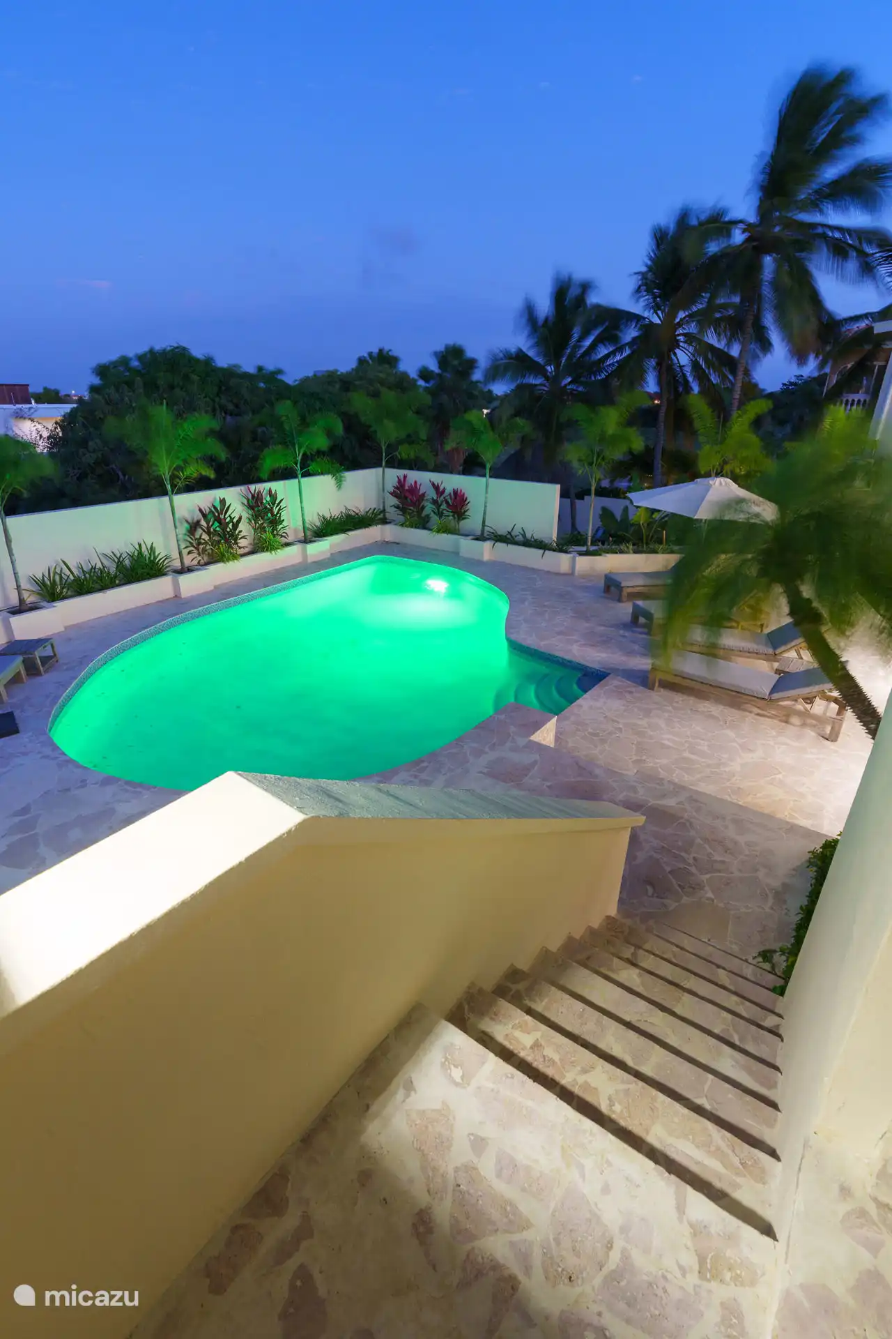 Schwimmbad mit Terrasse bei Nacht