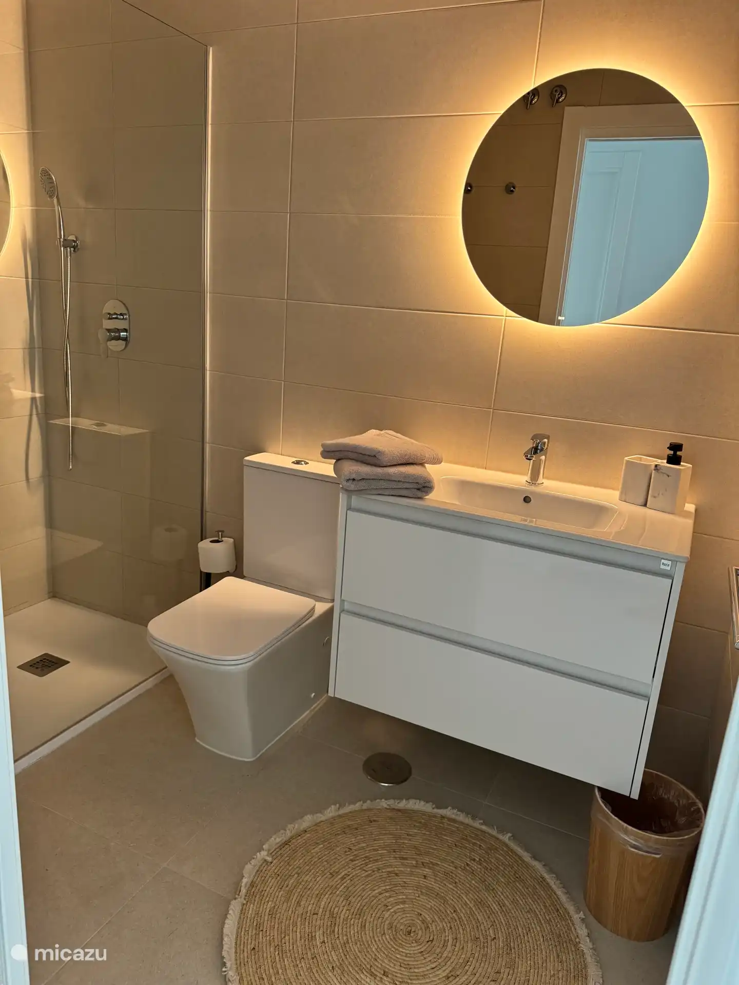 Baño de visitas con ducha a ras de suelo (ducha de lluvia), lavabo e inodoro. Cada baño tiene un secador de pelo y un secador de toallas. 