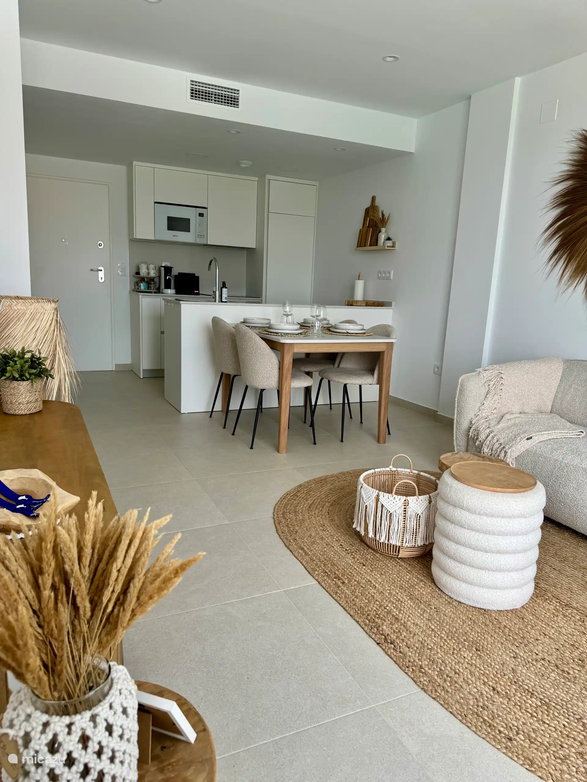 Sala de estar, comedor y cocina abierta con acogedor aspecto ibicenco 