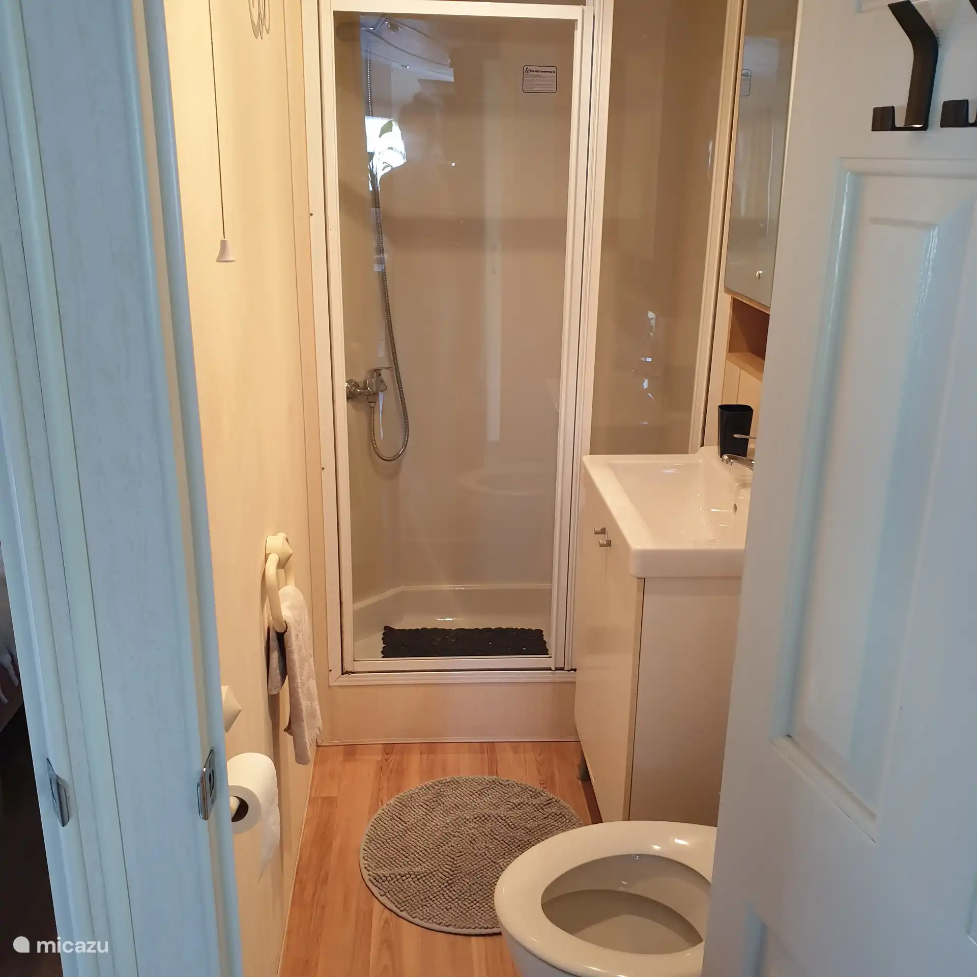 The bathroom with a shower, sink (cupboard), toilet. 