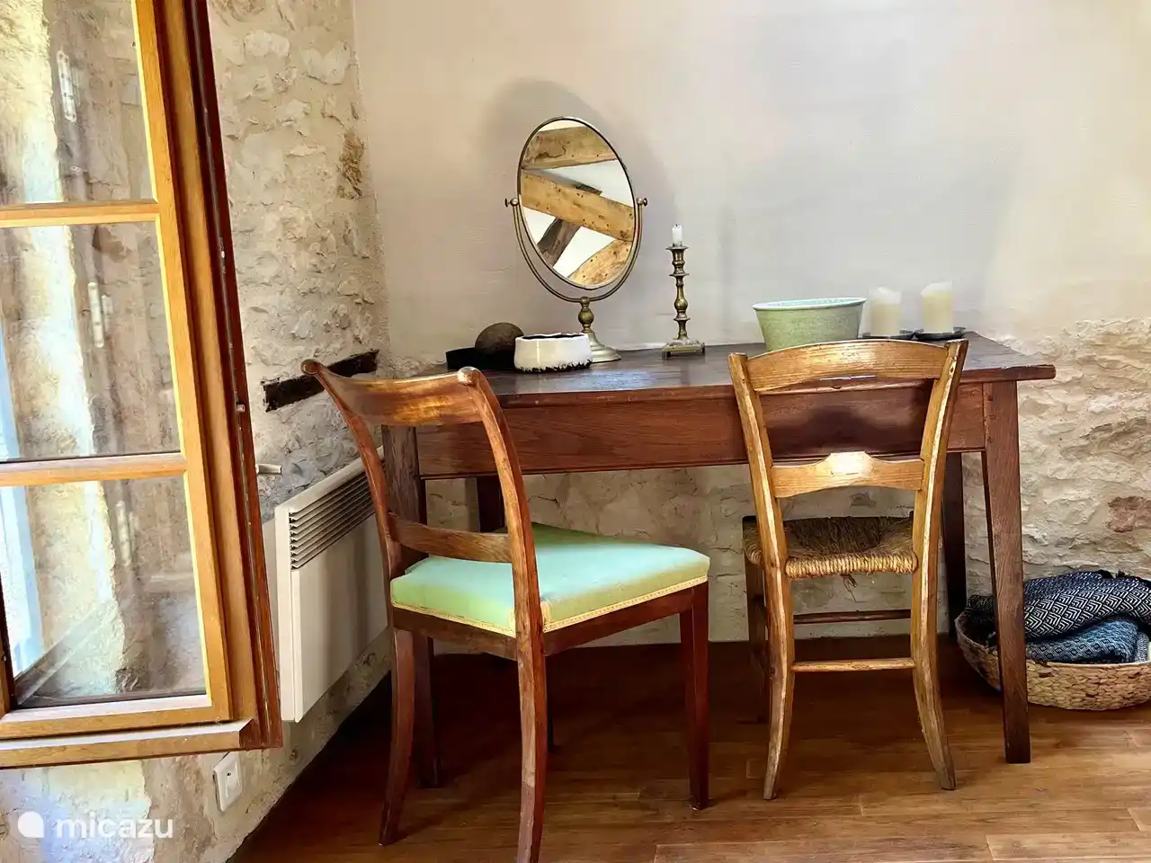 The old table with chairs and mirror in the corner of the main bedroom in the old barn.