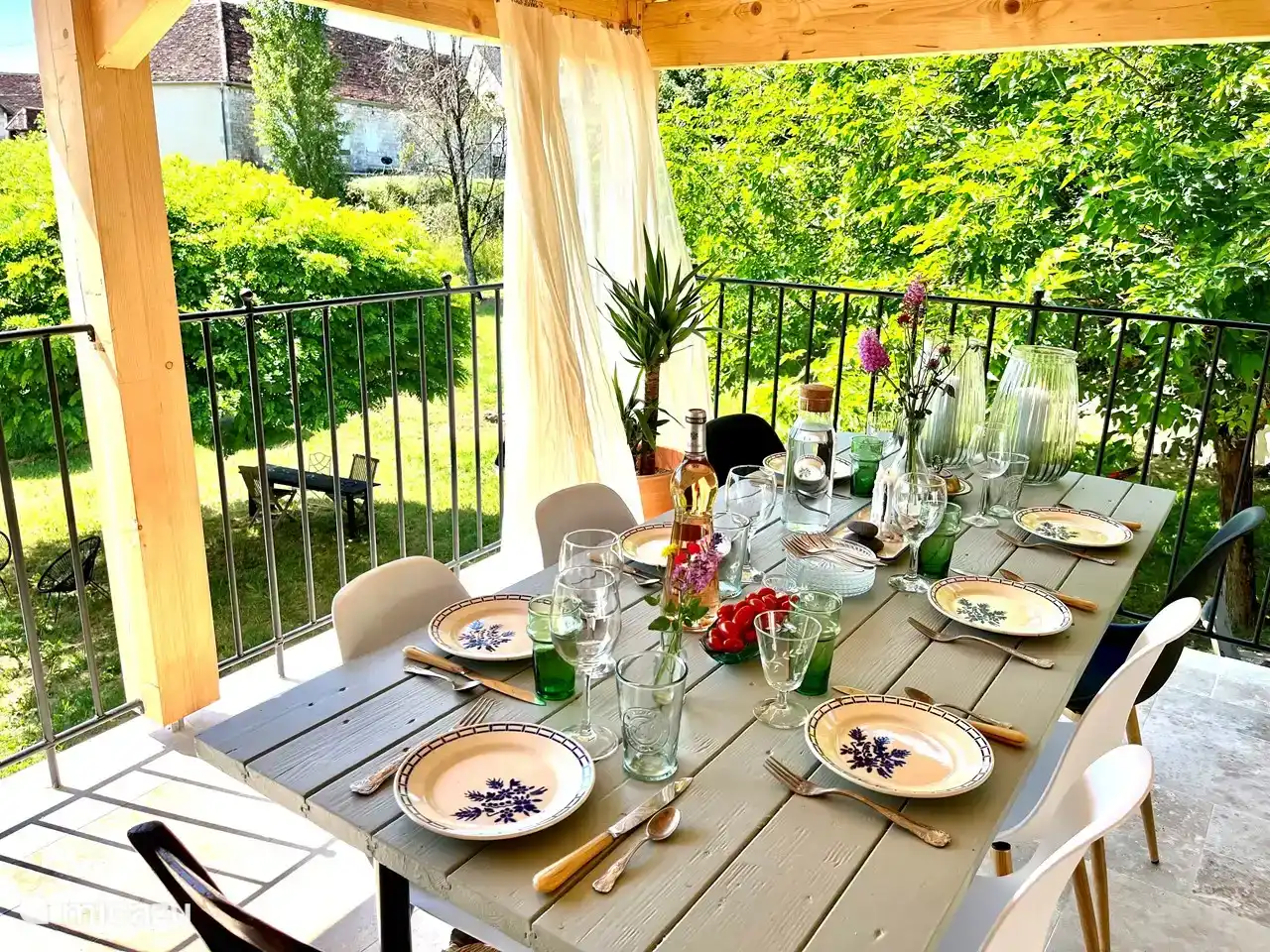 The covered terrace near the living room/kitchen. Here you will find a dining table, a lounger and two more chairs.