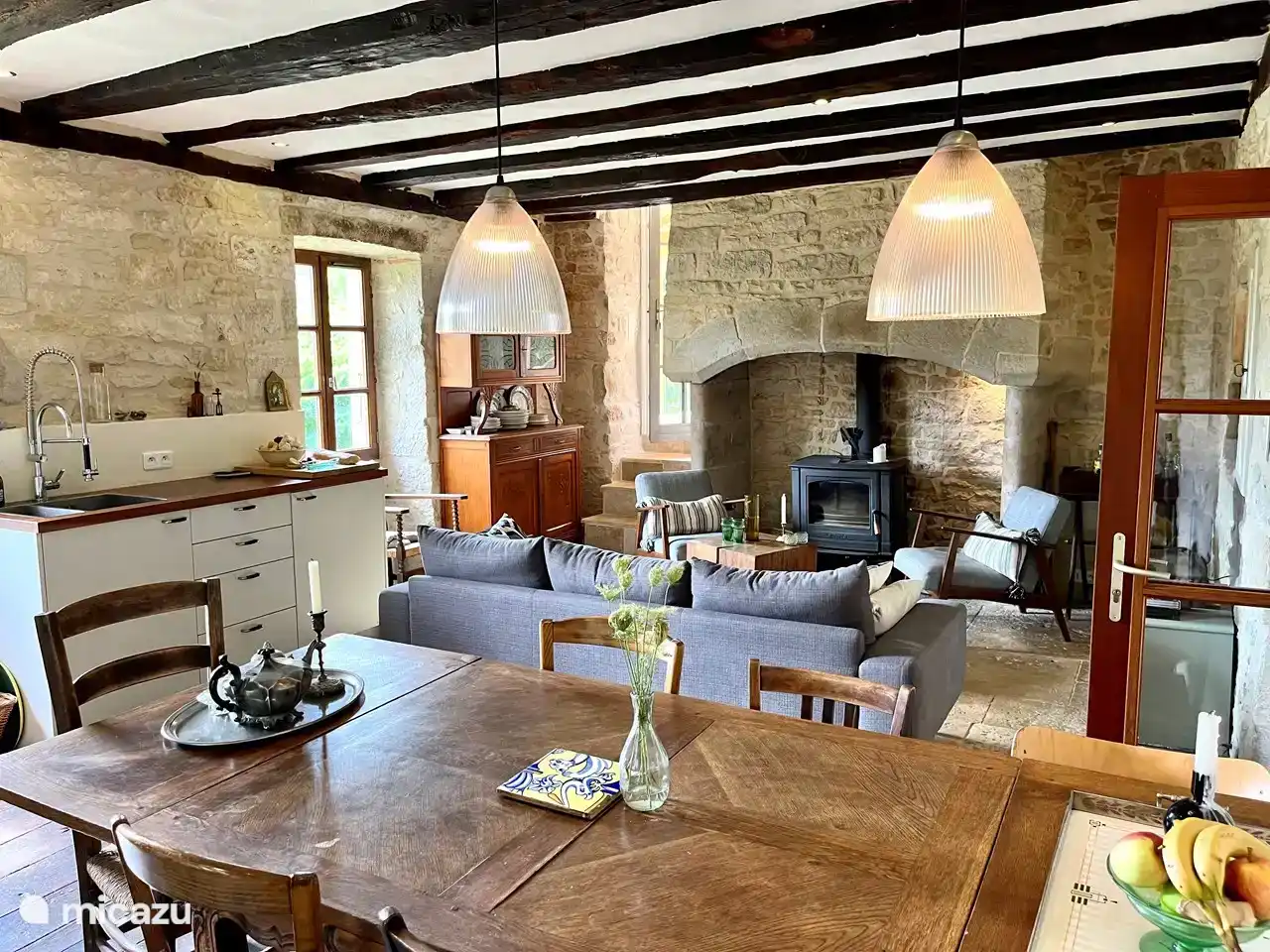 The living room / kitchen with large fireplace, wood stove and kitchen with large stove / oven.