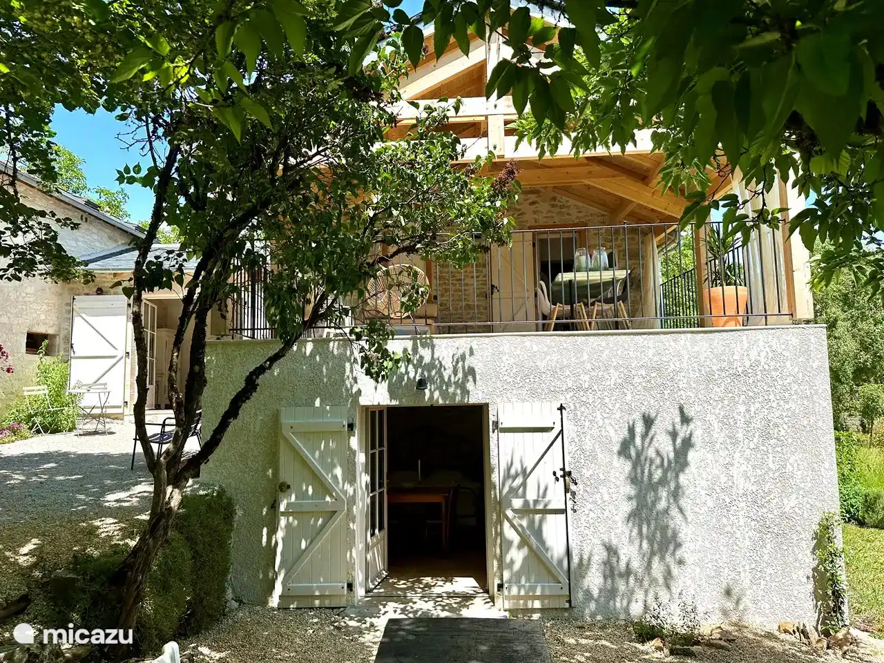 The terrace near the living room/kitchen, with the entrance to the studio underneath and a piece of the large outdoor table in front of it.