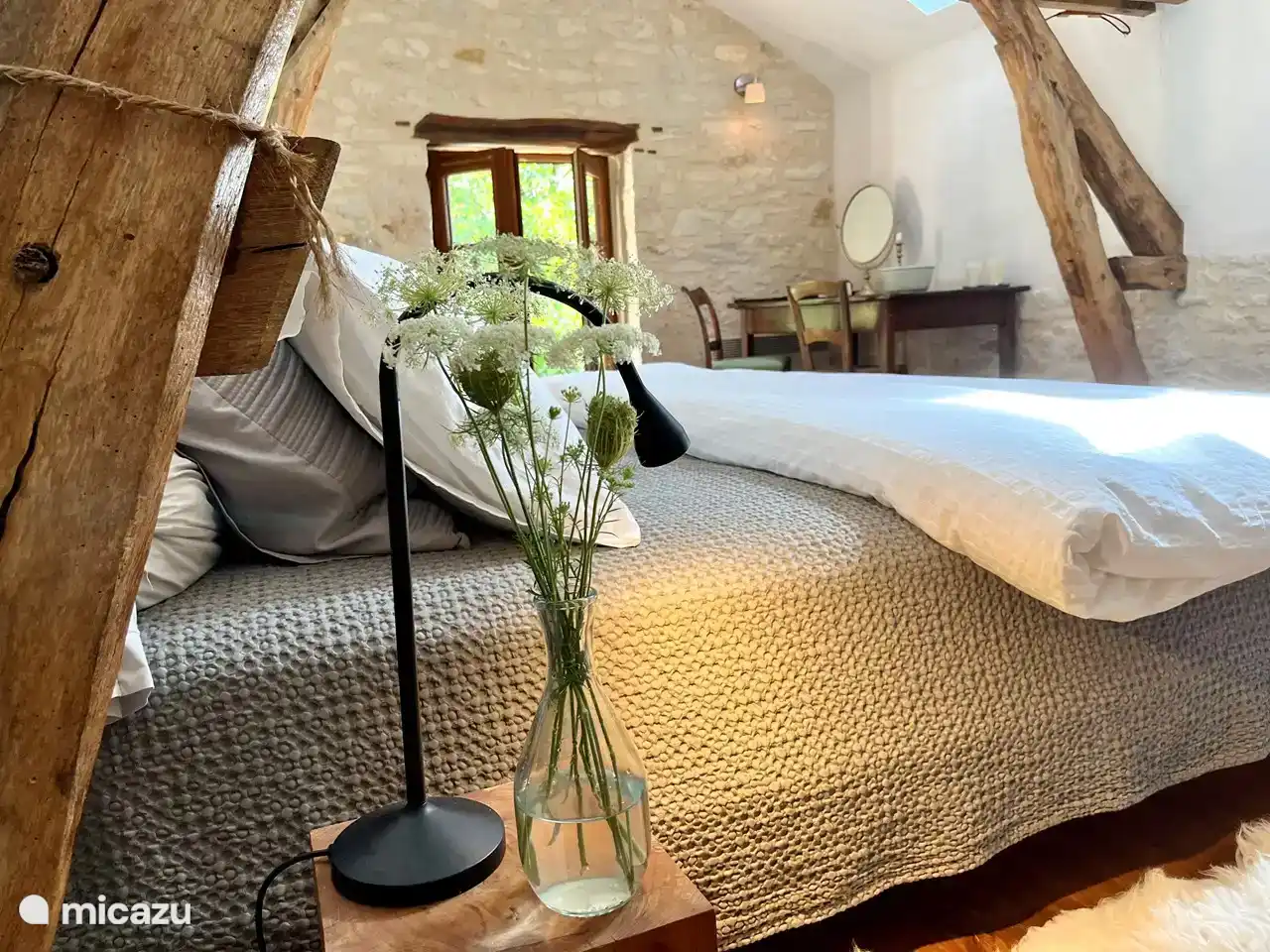 The large bedroom upstairs in the old barn, with double bed, coffee &amp; tea corner, cupboard, beautiful old table and door to the private covered terrace with double outdoor bed.