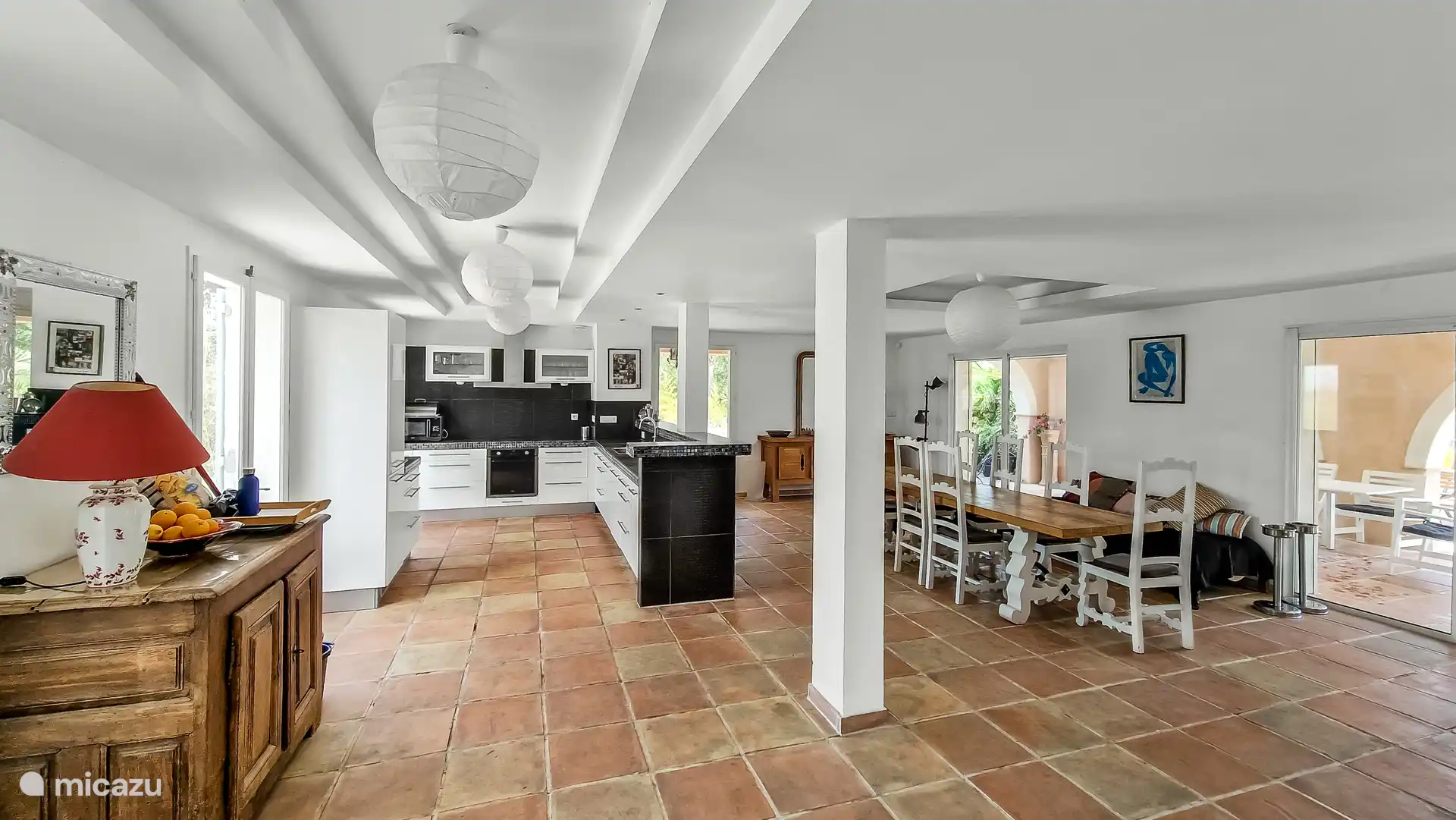 Offene Küche mit Essbereich und Schiebetüren zur überdachten Terrasse