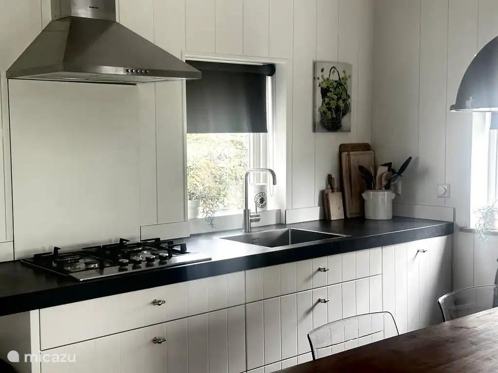 Nuestra amplia cocina con un gran armario con microondas, nevera-congelador y horno a la derecha.