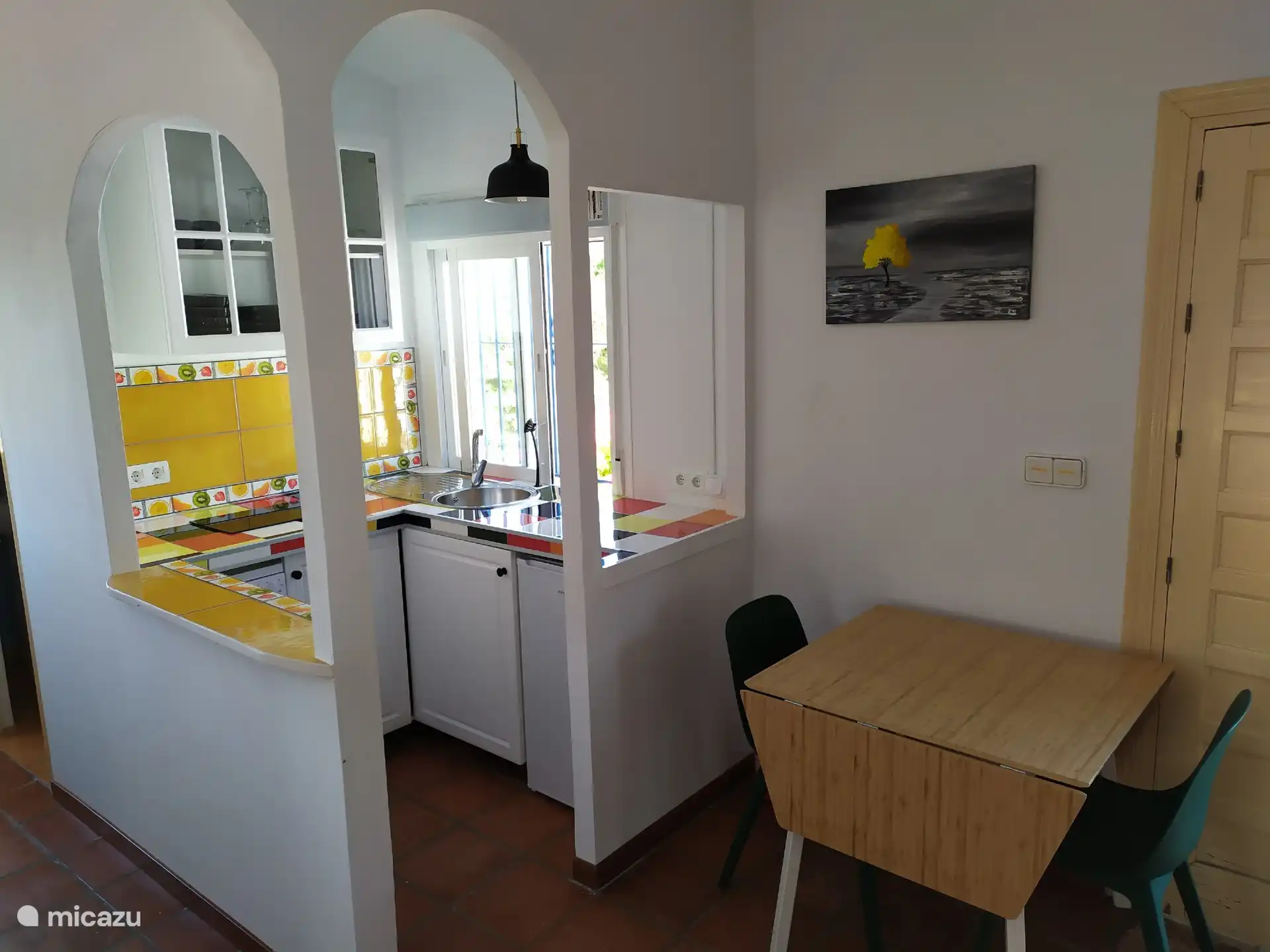 Kitchenette with dishwasher, refrigerator and electric hob.