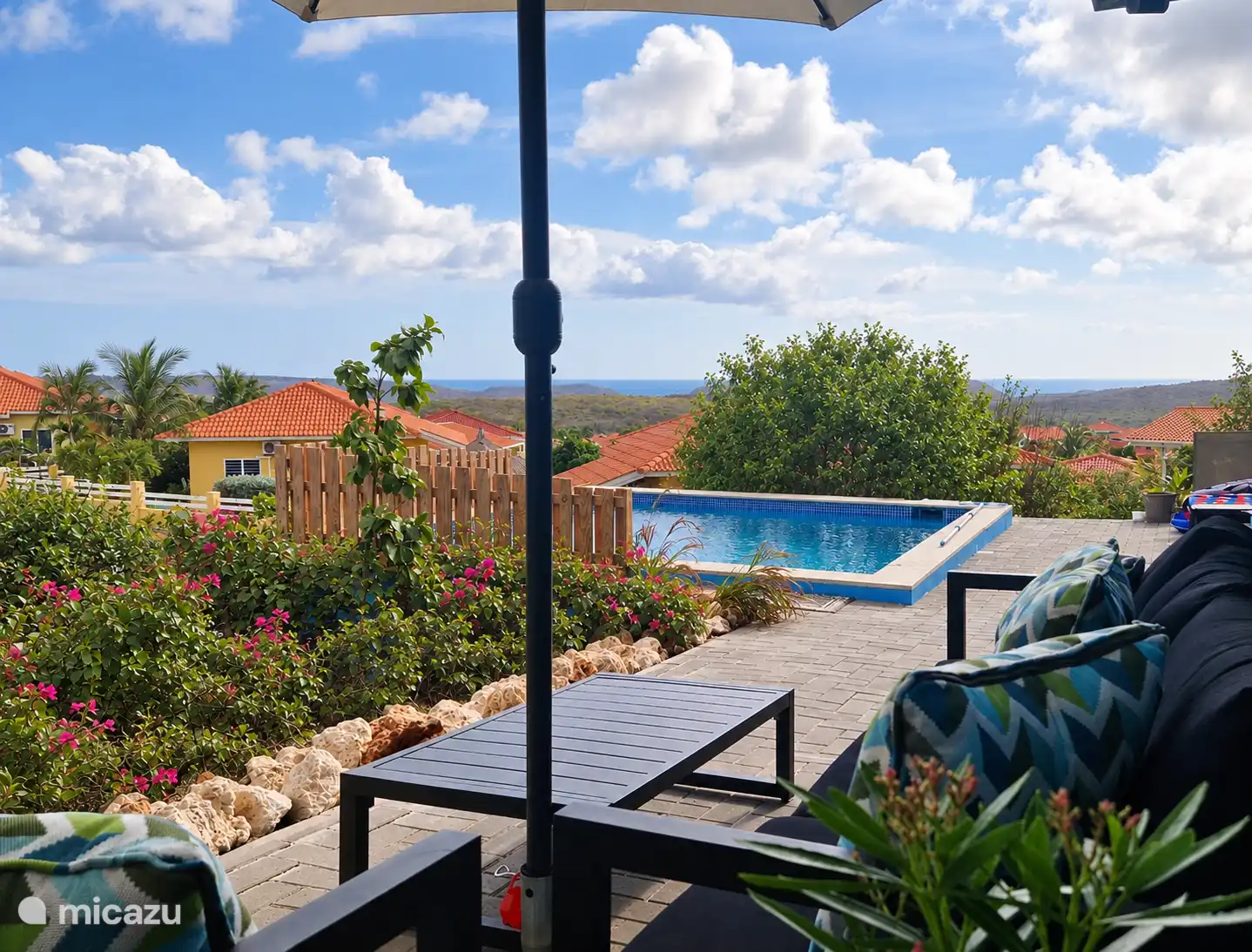 Un lugar encantador para descansar en un lateral de la casa con vistas al jardín y la piscina, colinas y mar
