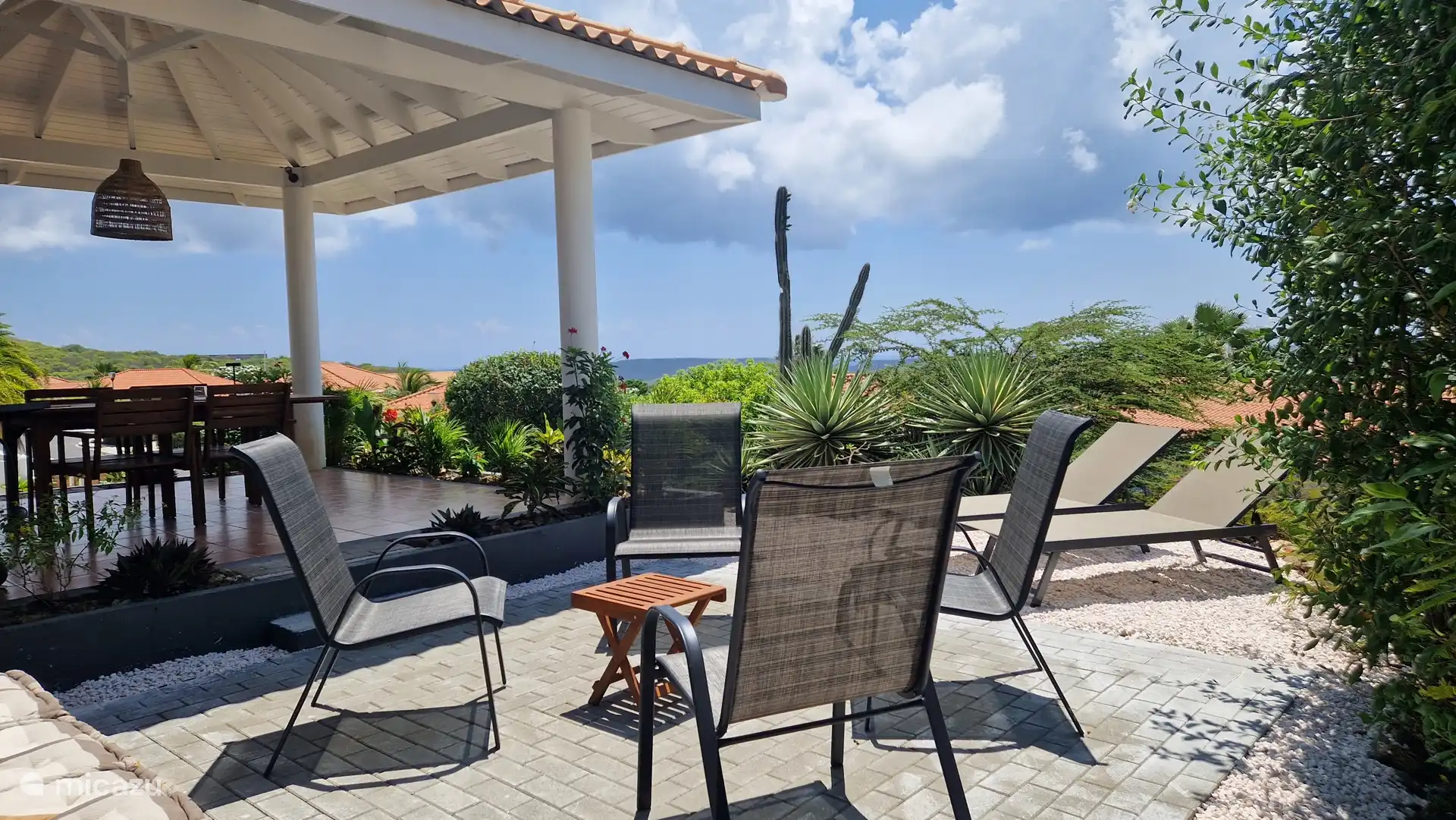 Terrasse spacieuse avec chaises confortables et banc au look de plage