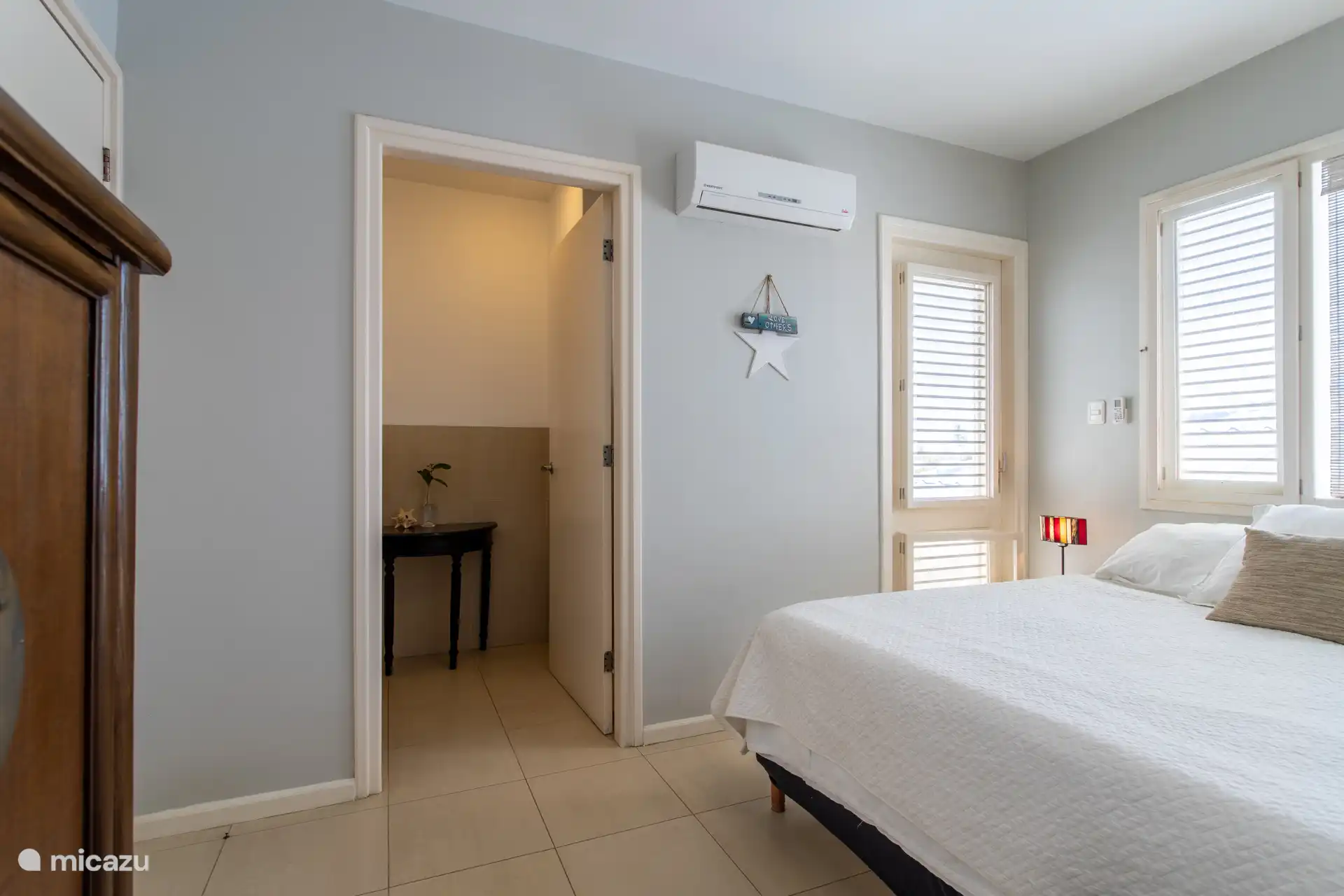 Second bedroom with kingsize bed and bathroom with shower and vanity.