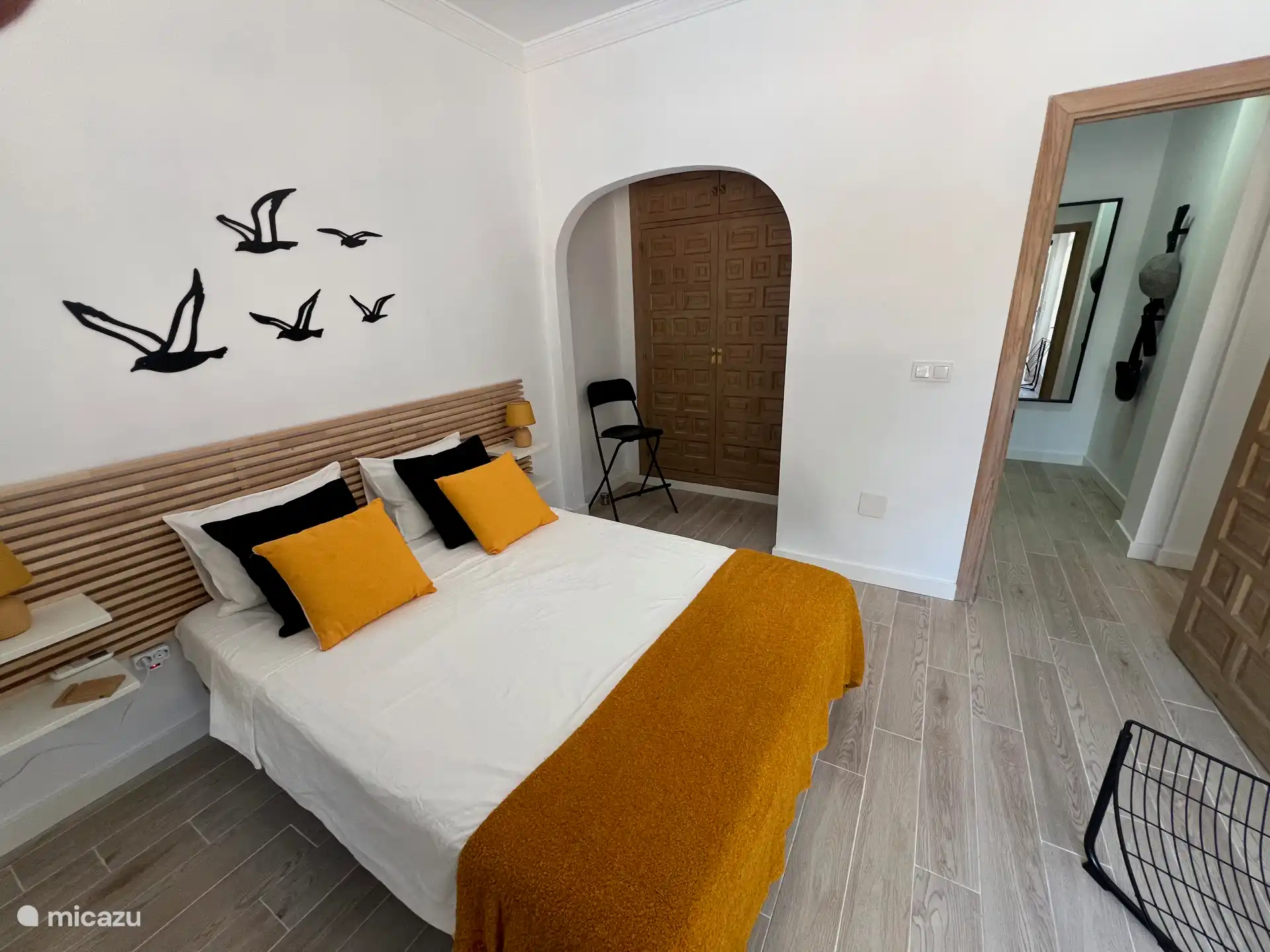 Im Schlafzimmer sehr großer Einbauschrank mit Spiegel mit Garderobe im Flur.