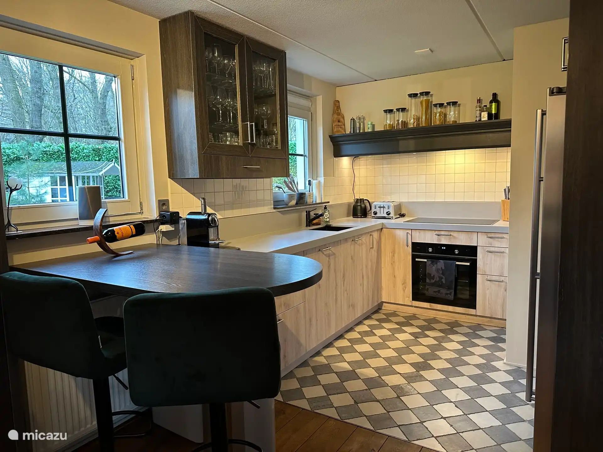 Cuisine avec plaque à induction (5 zones), four à air chaud/vapeur, grand réfrigérateur et congélateur, micro-ondes (dans le placard au-dessus du réfrigérateur) et lave-vaisselle.