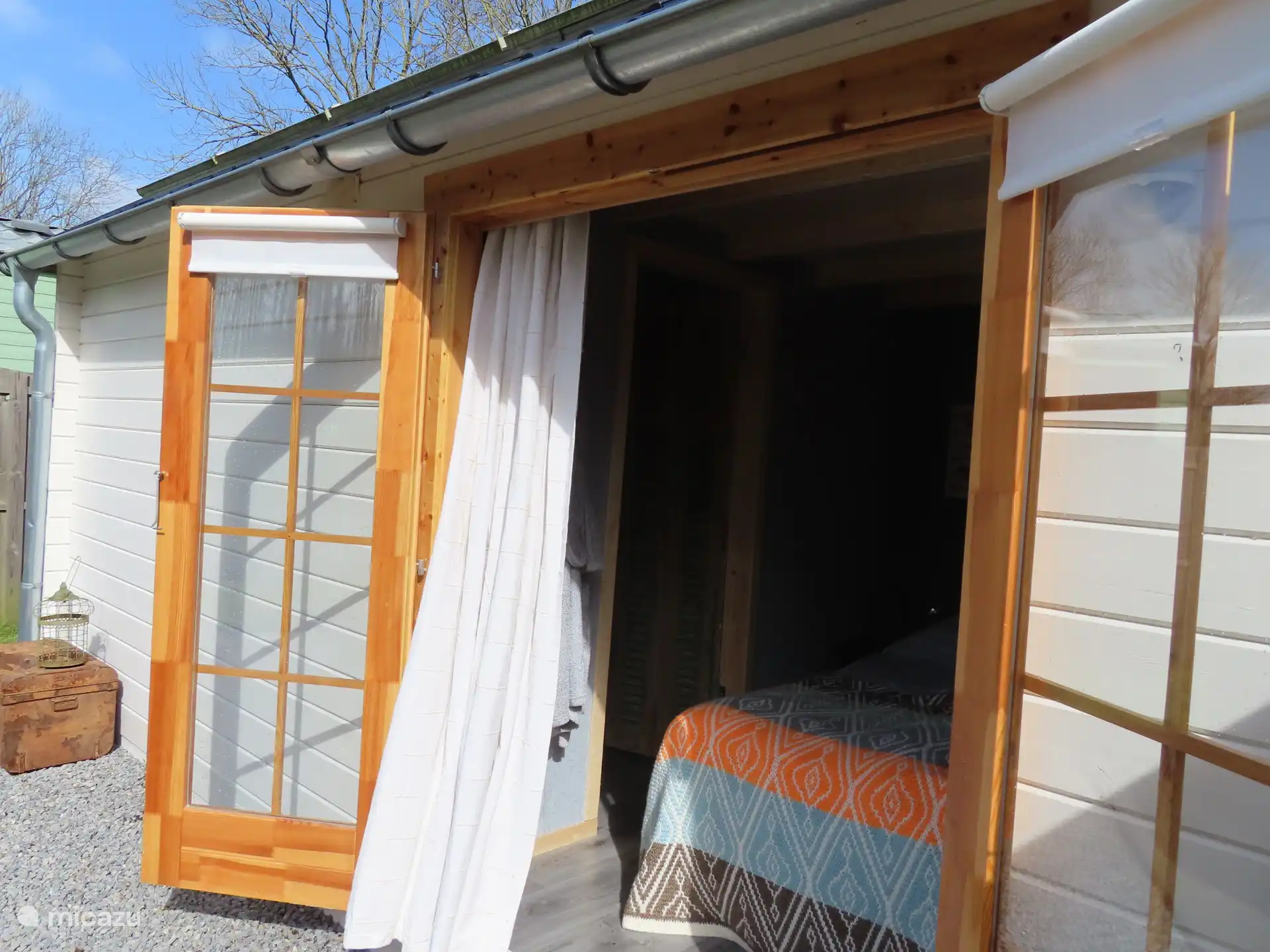 Hauptschlafzimmer mit Terrassentüren und freiem Blick auf Garten und Wiese.