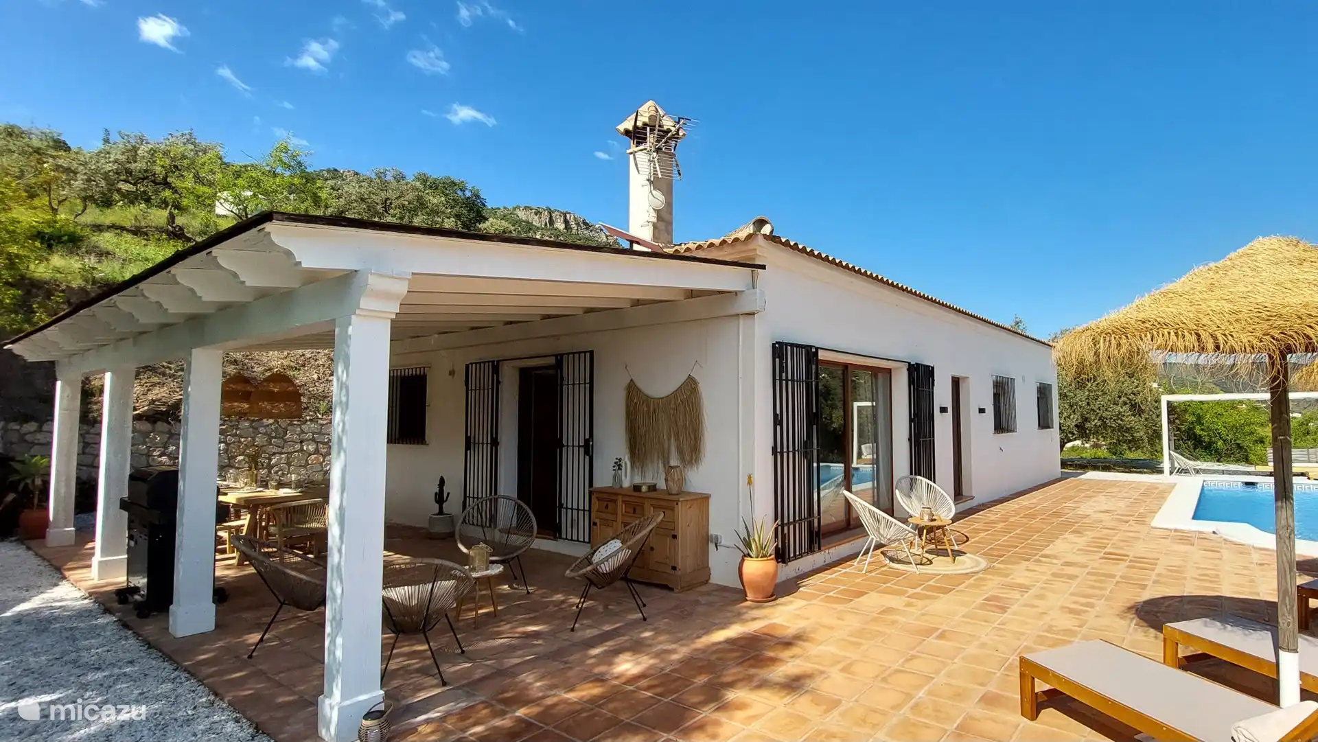 overdekt terras met 8 persoons eettafel en gas bbq