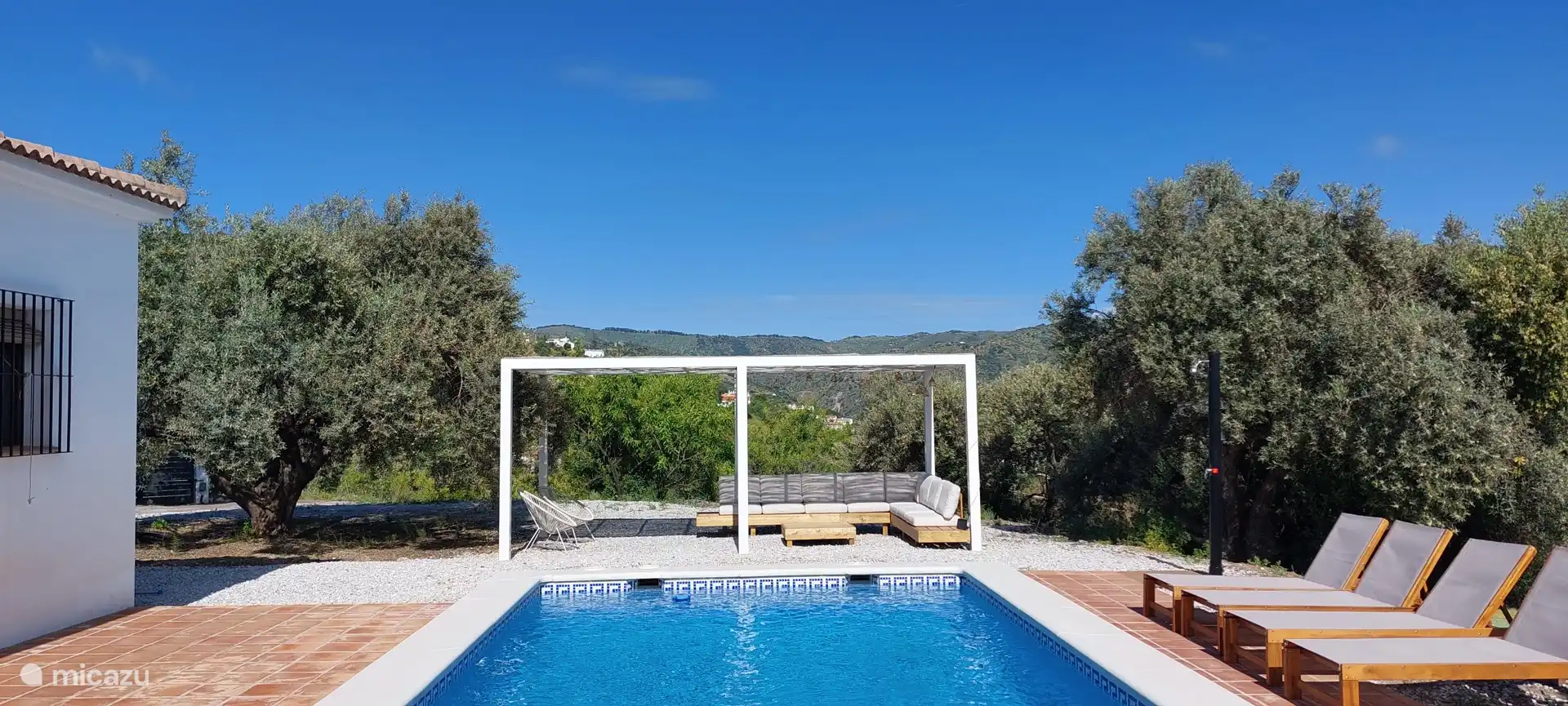 Rustige plek in de schaduw met uitzicht over het zwembad.