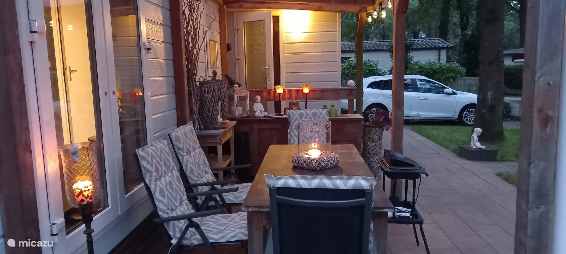 Eettafel buiten in de avond met zicht op prive parkeerplaats