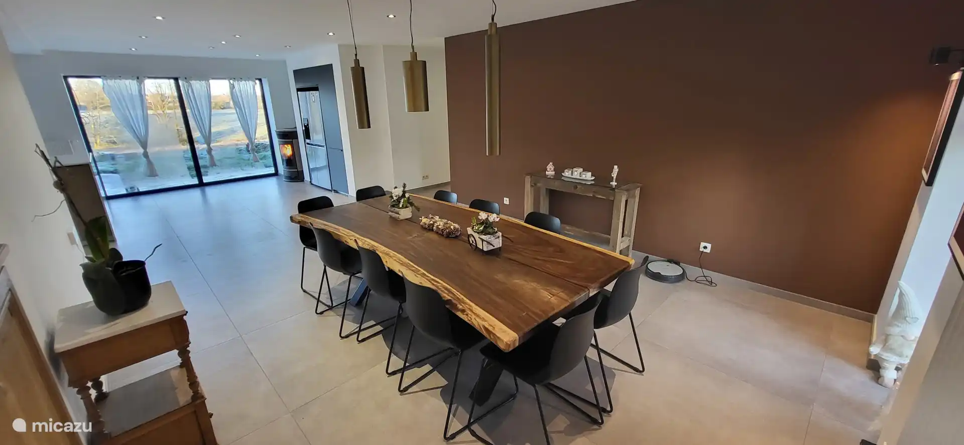 Amplia sala de estar luminosa con una mesa de madera maciza que puede acomodar todas sus comidas de convivencia. Vistas al campo, estufa de pellets y ambiente cálido garantizado.