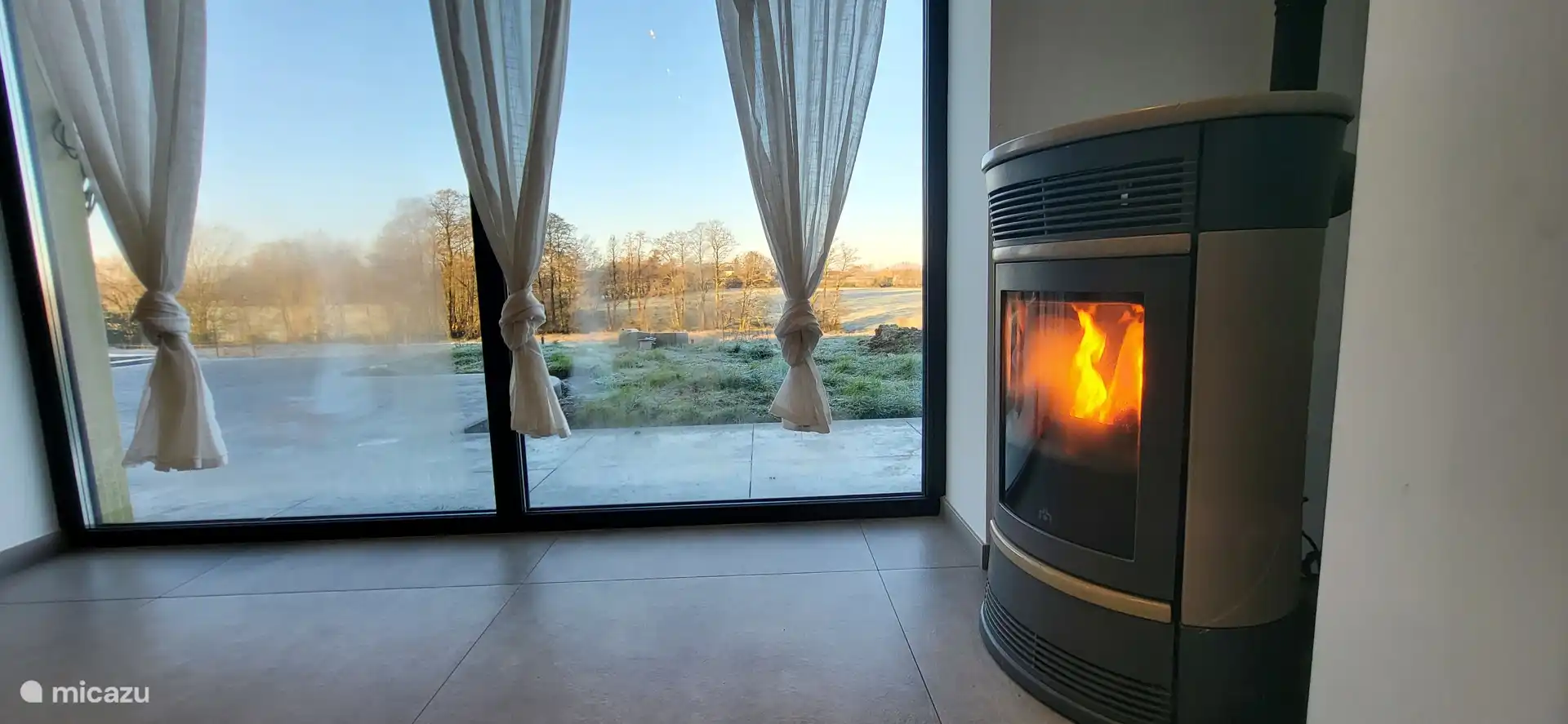 Gran ventanal con impresionantes vistas de la naturaleza circundante, acogedor rincón con estufa de pellets para un ambiente cálido en todas las estaciones. Ideal para relajarse frente al paisaje.