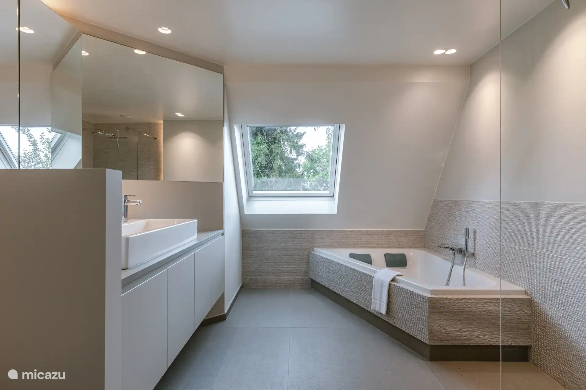 Straßenseitiges Badezimmer mit luxuriöser Badewanne für zwei Personen, Dusche und Waschbecken für 2 Personen.