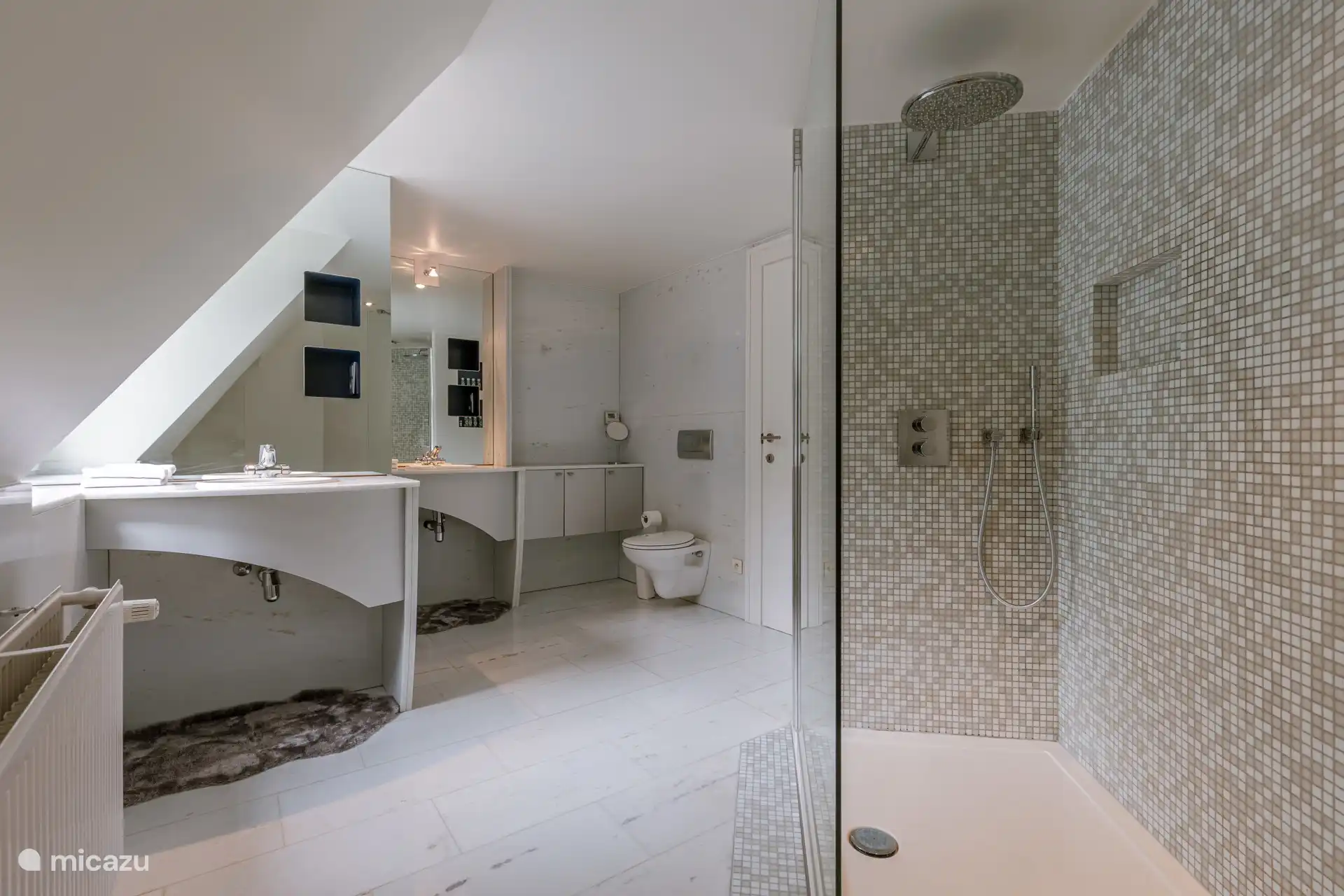 Das Towerside-Badezimmer ist mit natürlichem Carrara-Marmor verkleidet.  
Dusche, WC, 2 Waschbecken und nebenstehende Saunakabine