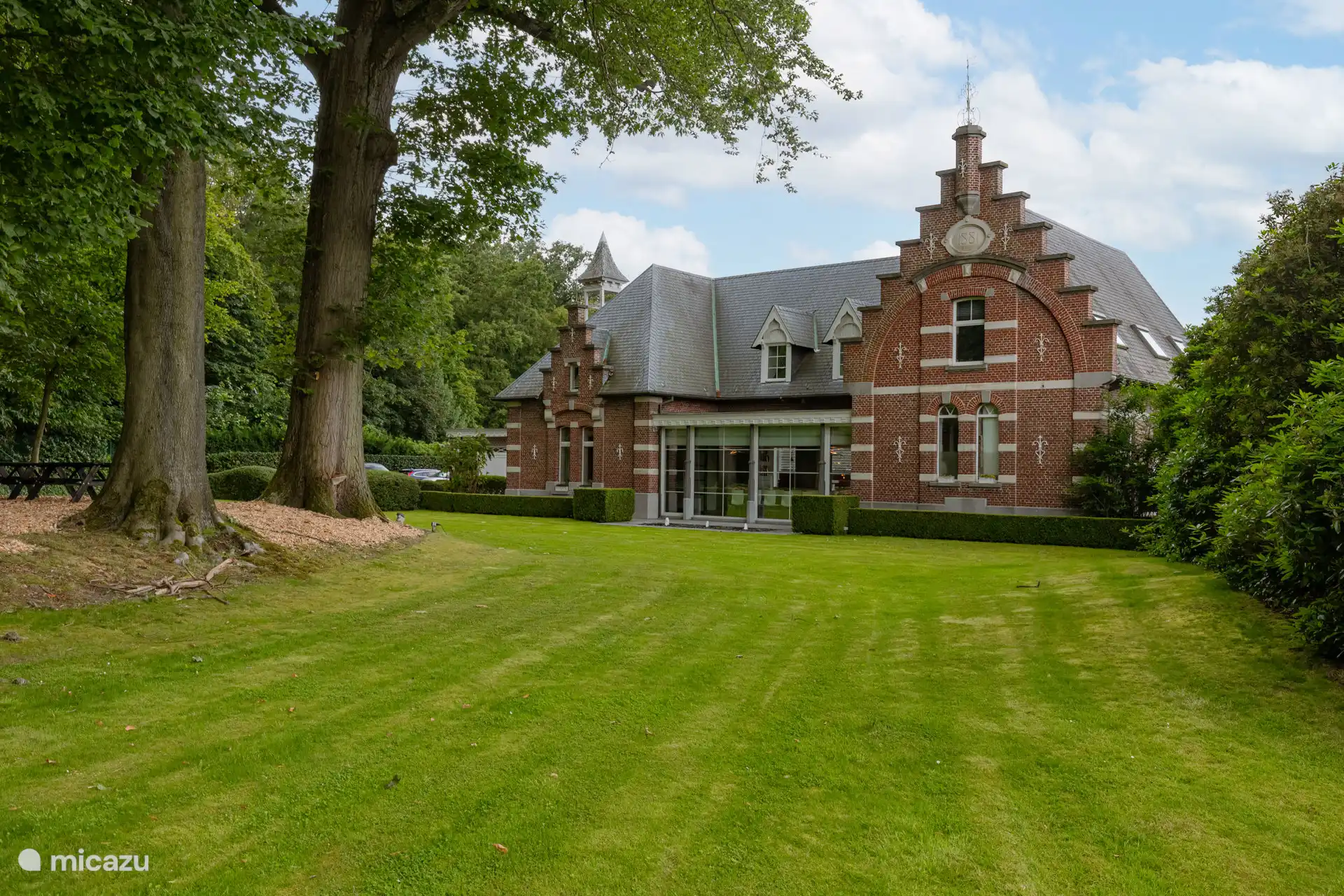 Historische Fassade des jahrhundertealten Kutscherhauses aus dem Jahr 1881.  Atemberaubender Blick auf die riesigen Eichen, Buchen, Kastanienbäume. 