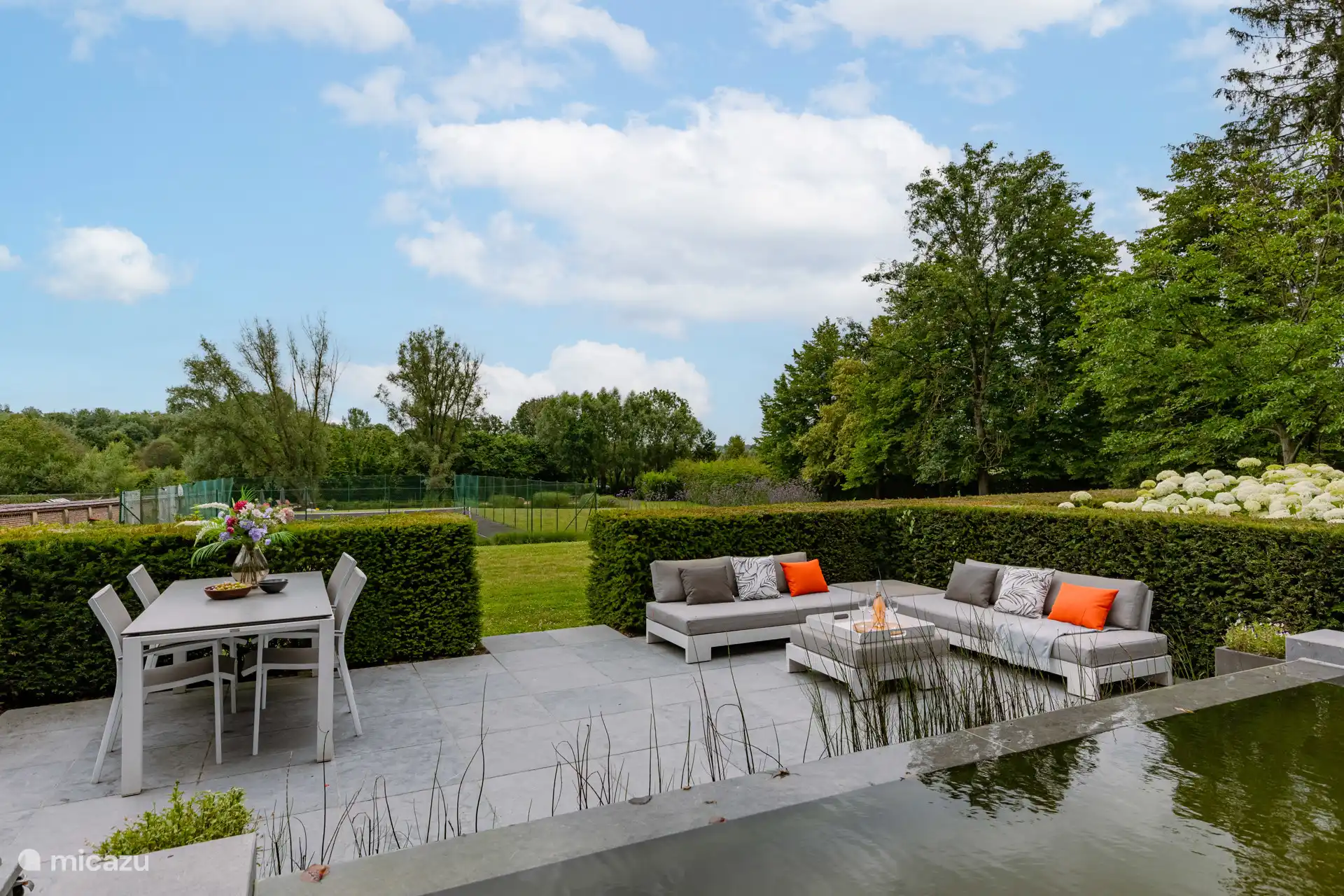 Gemütliche, großzügige Terrasse an einem dekorativen Wasserfall.  