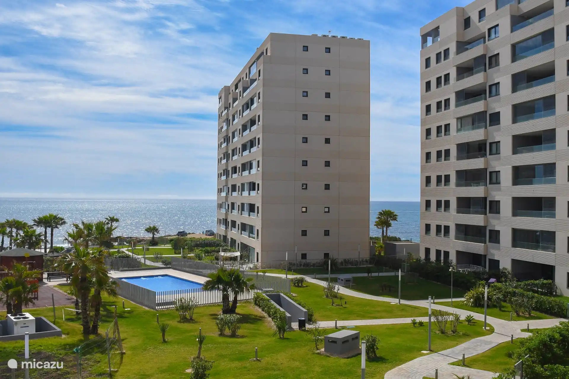 La piscine ici sur la photo est une grande pataugeoire avec une aire de jeux à côté.  Photo prise depuis la terrasse