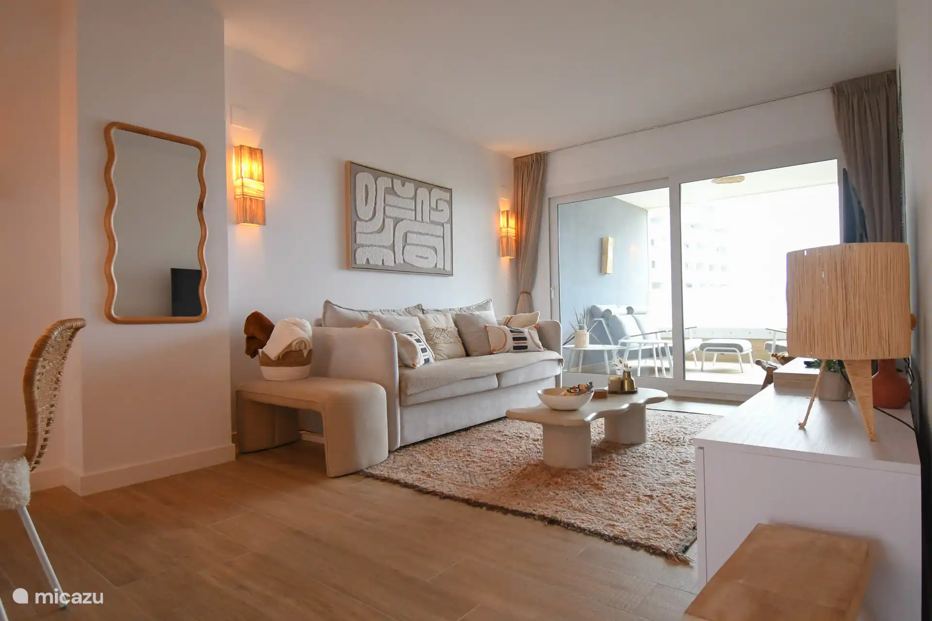 Salon avec canapé convertible, google tv, jeux dans le placard, vue mer extérieur par grande fenêtre coulissante, passage terrasse