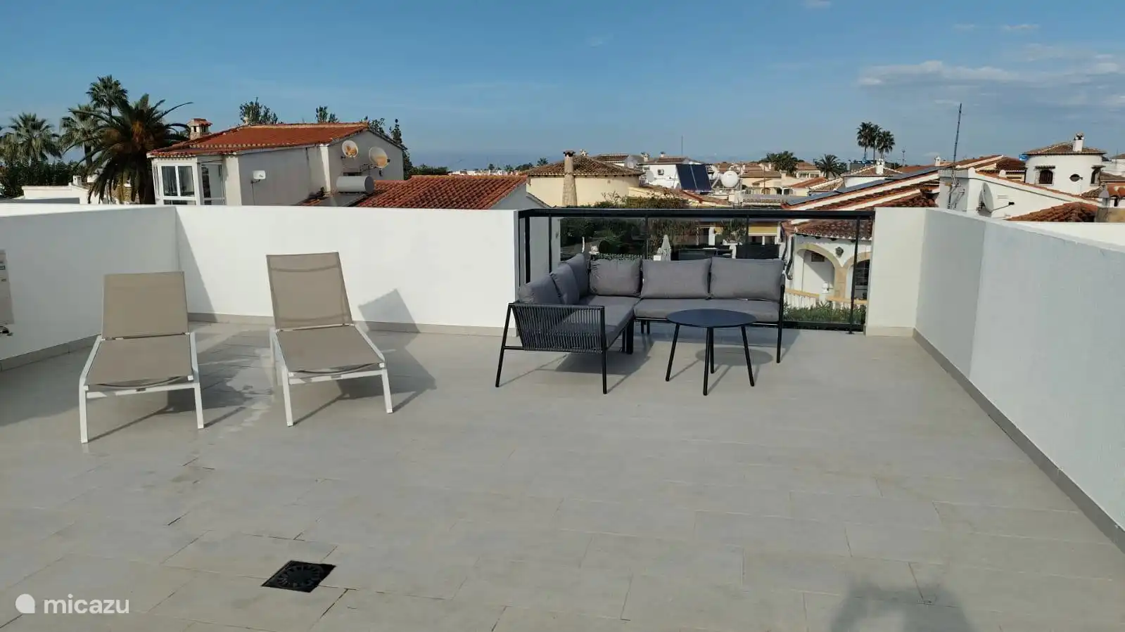 Sunbeds and lounge set on roof terrace