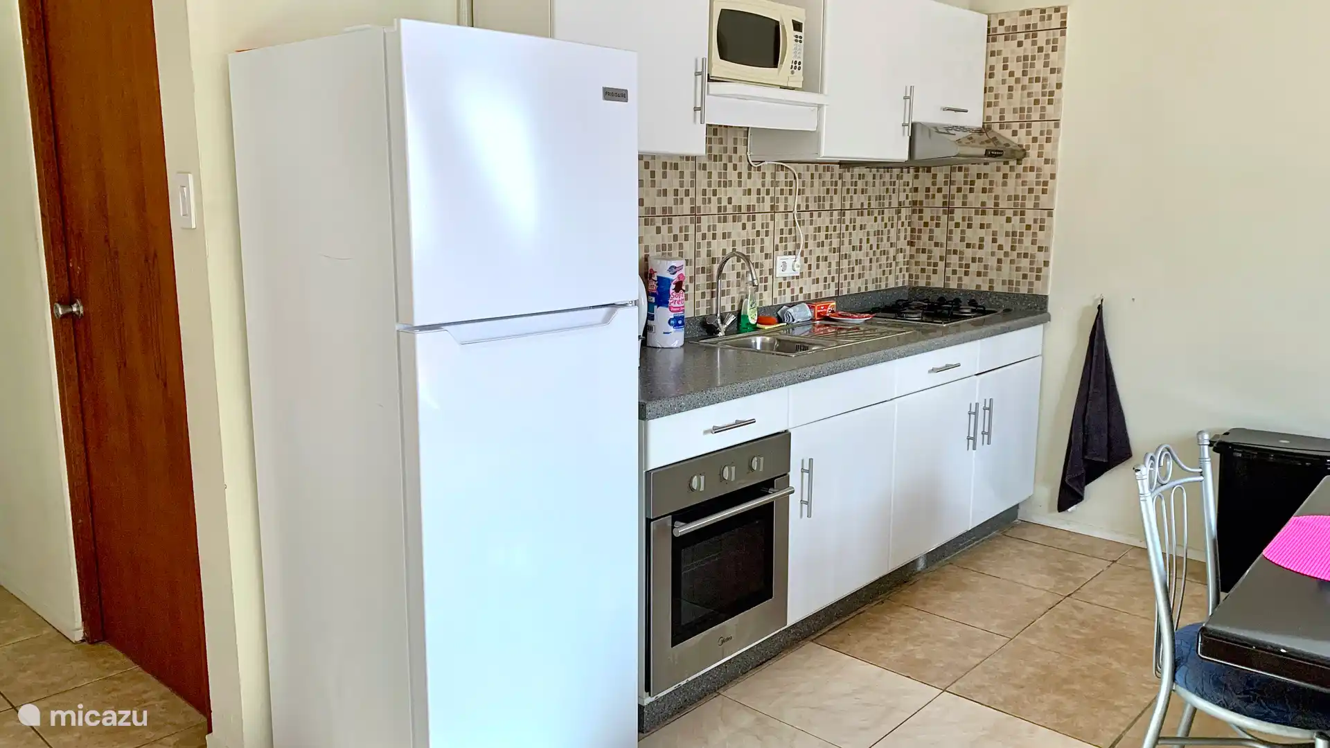Fully equipped kitchen with stove, oven, microwave, coffee maker, kettle, refrigerator, plates, cutlery, pans, pots, etc.