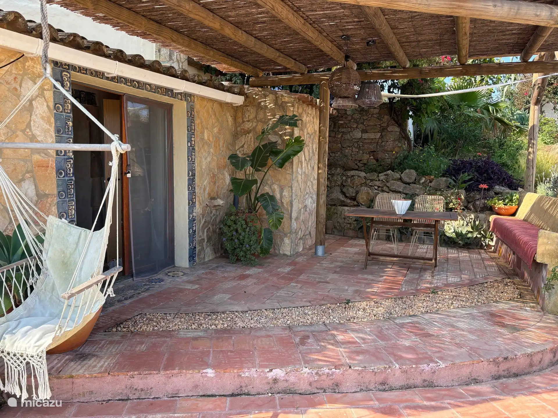 Haustür mit Terrasse, Pergola und Sitzgelegenheiten zum Essen oder Chillen. Dieses Gebiet ist von Lavendel, Bougainvillea und Sukkulenten umgeben.