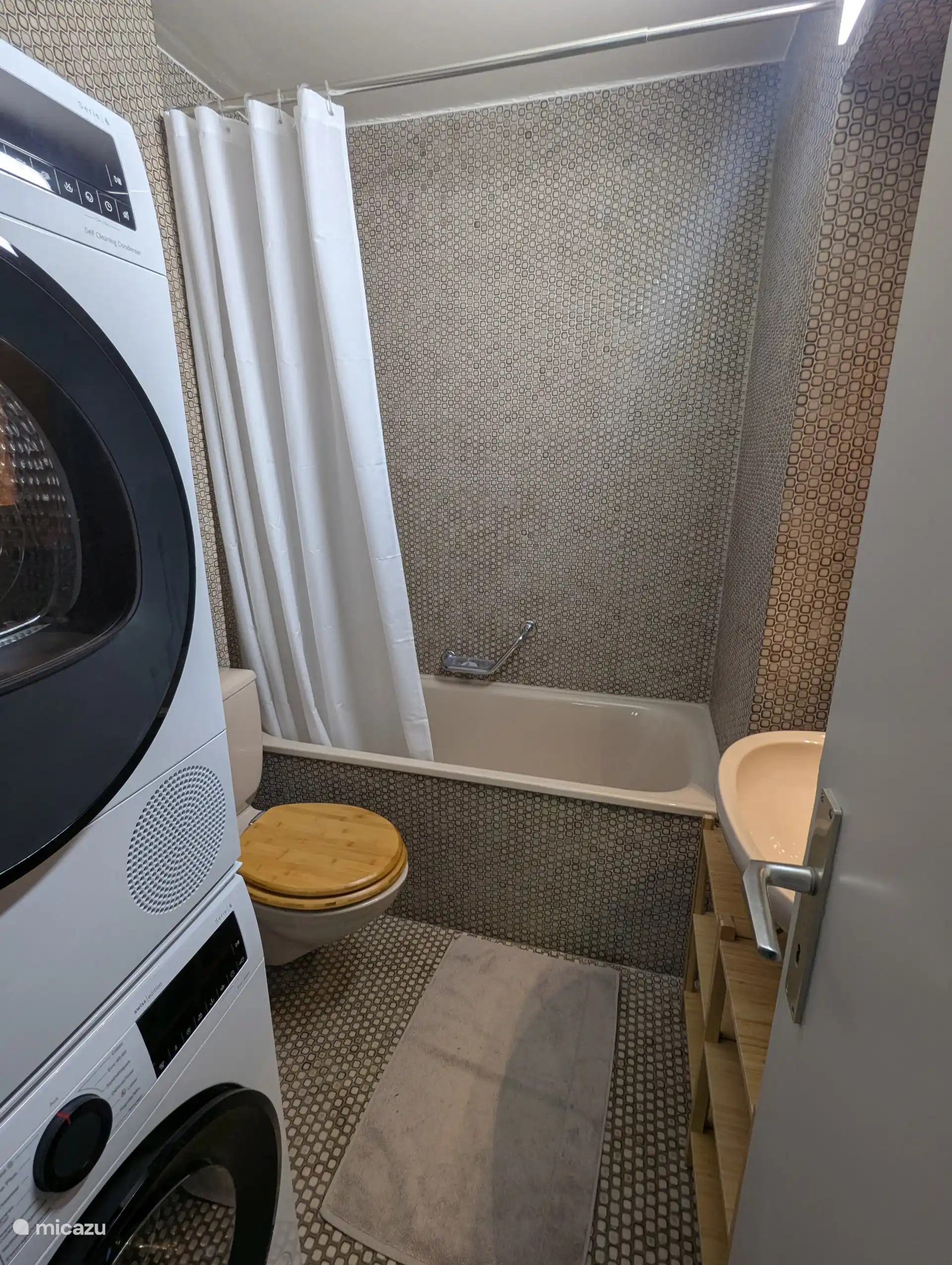 The bathroom with bath/shower, sink, toilet and the washer and dryer.