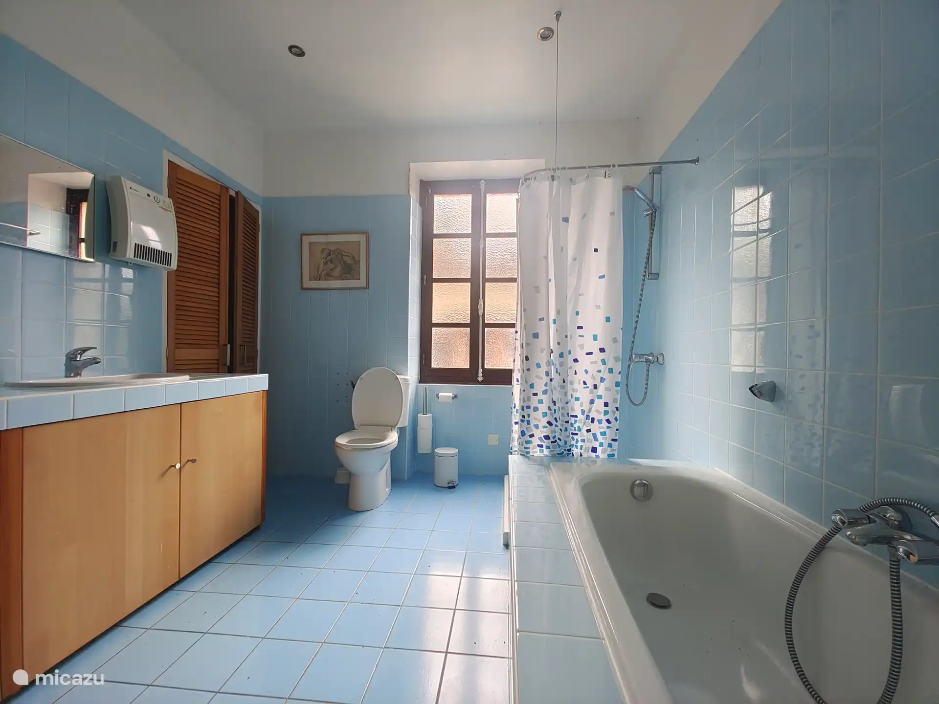 Ein Badezimmer mit Badewanne, Doppelwaschbecken und WC sowie eine zusätzliche separate Toilette. 