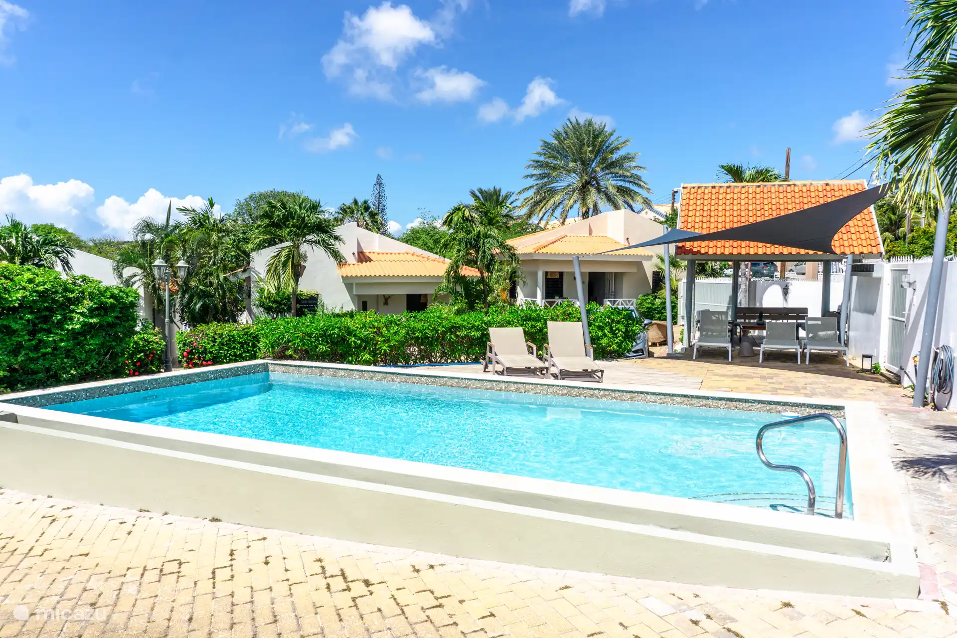 Piscina comunitaria con tumbonas