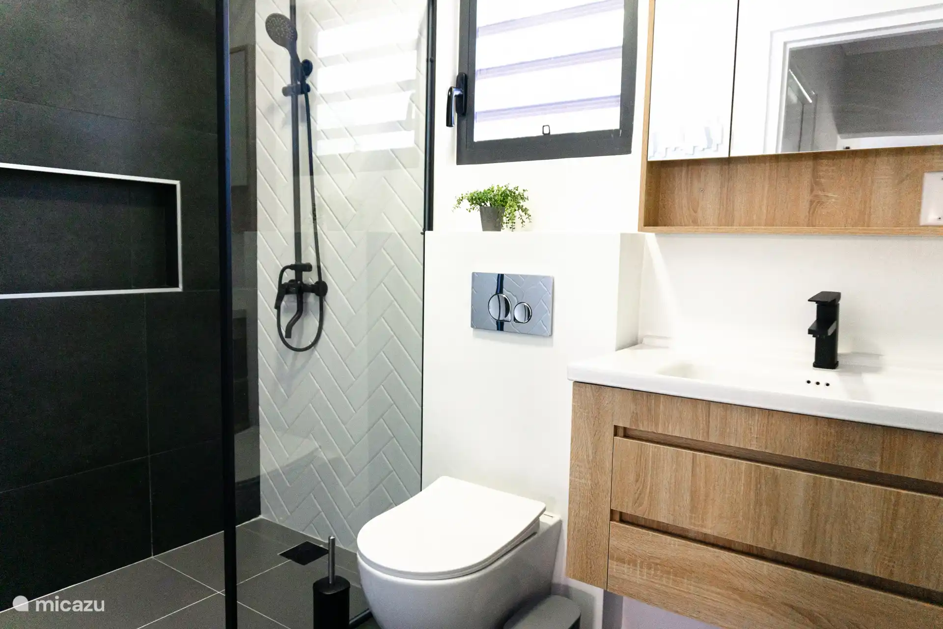 Baño con ducha a ras de suelo, inodoro y lavabo