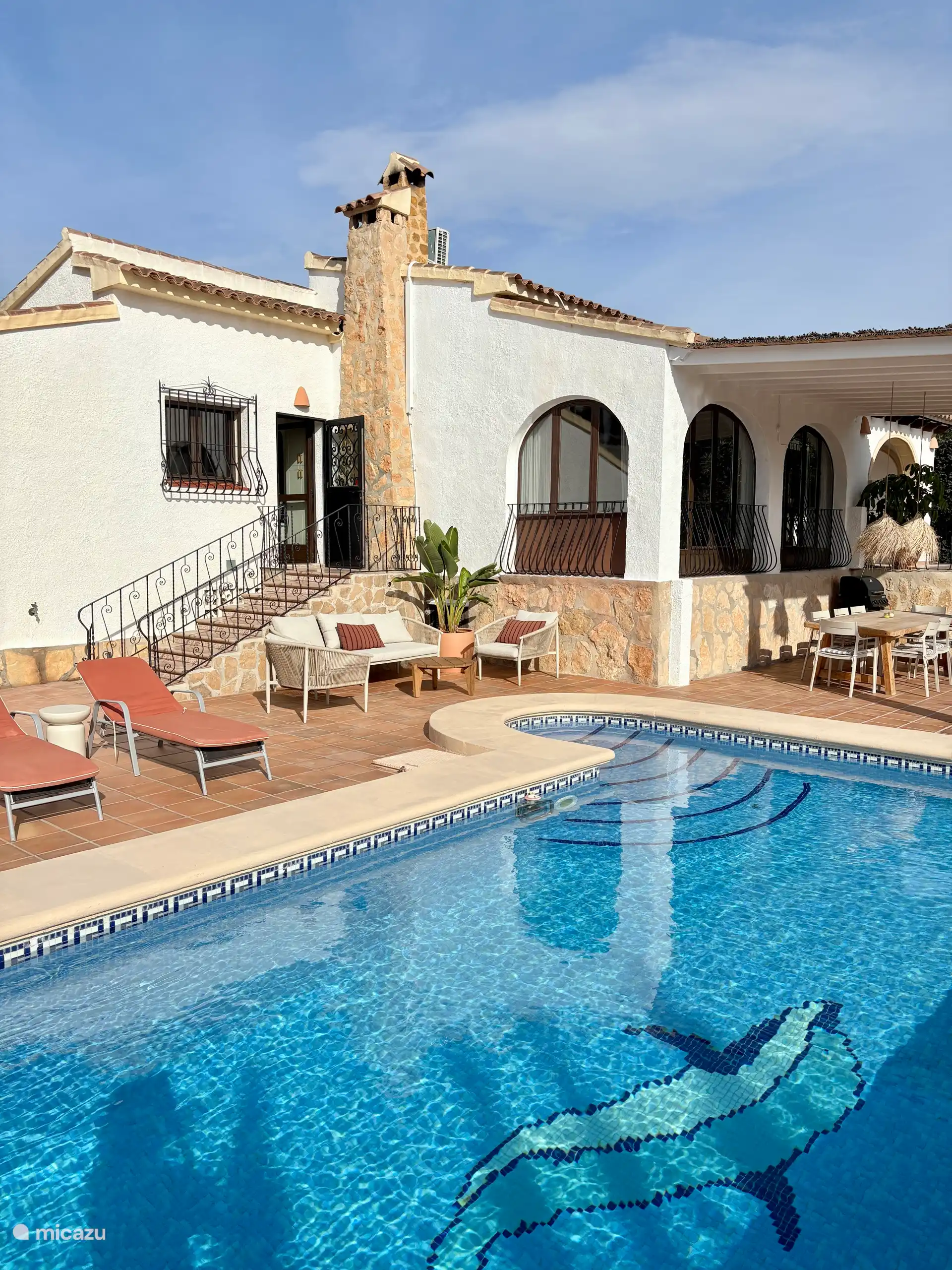 Buiten vind je een grote overkapping met een grote eettafel, 8 stoelen een een gas BBQ.