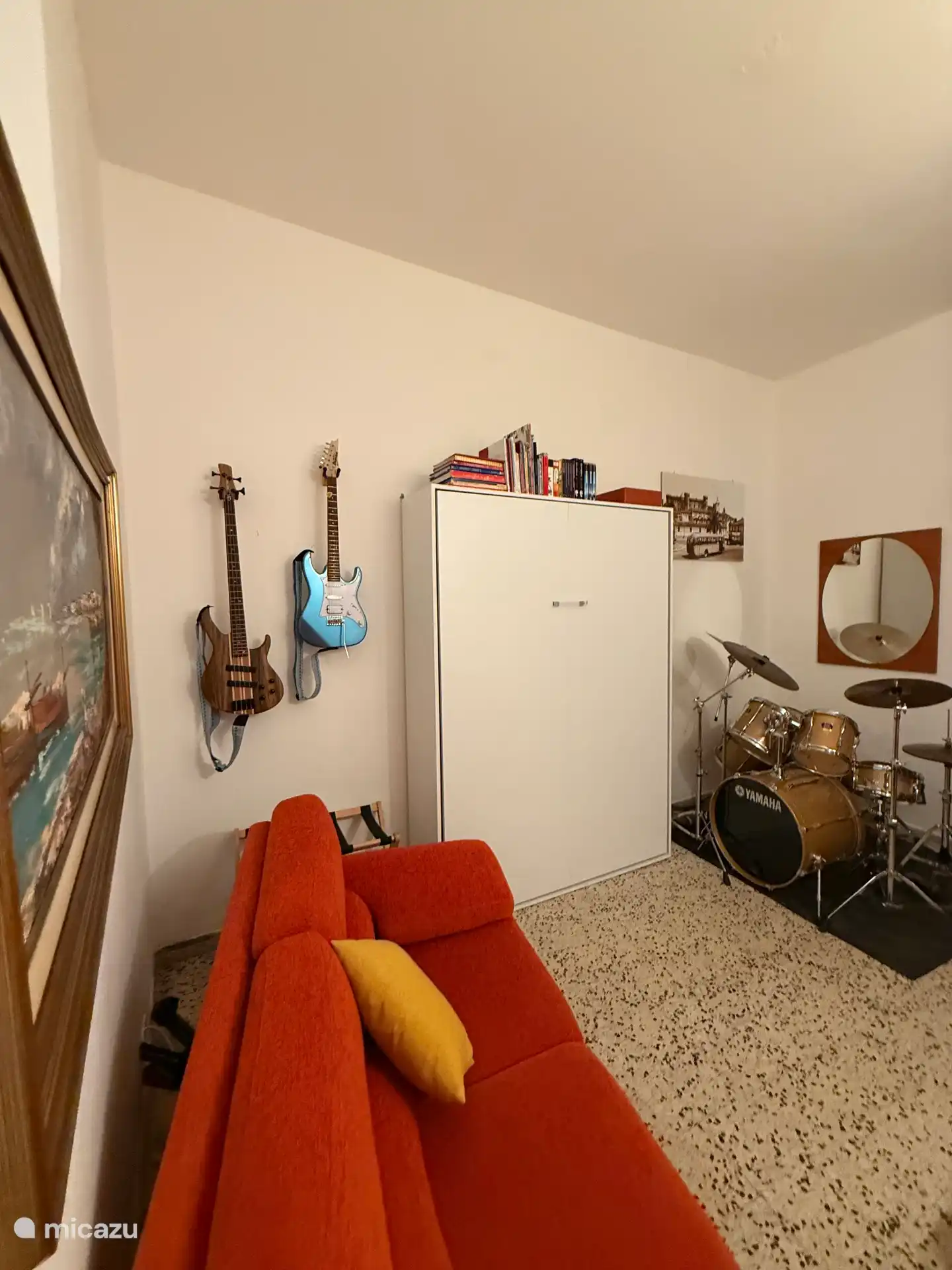 Gemütliches Wohnzimmer zum Thema Musik mit Wandbett, Gitarren und Schlagzeug – ein kreativer und entspannender Ort in Bracciano in der Nähe des Römischen Sees.