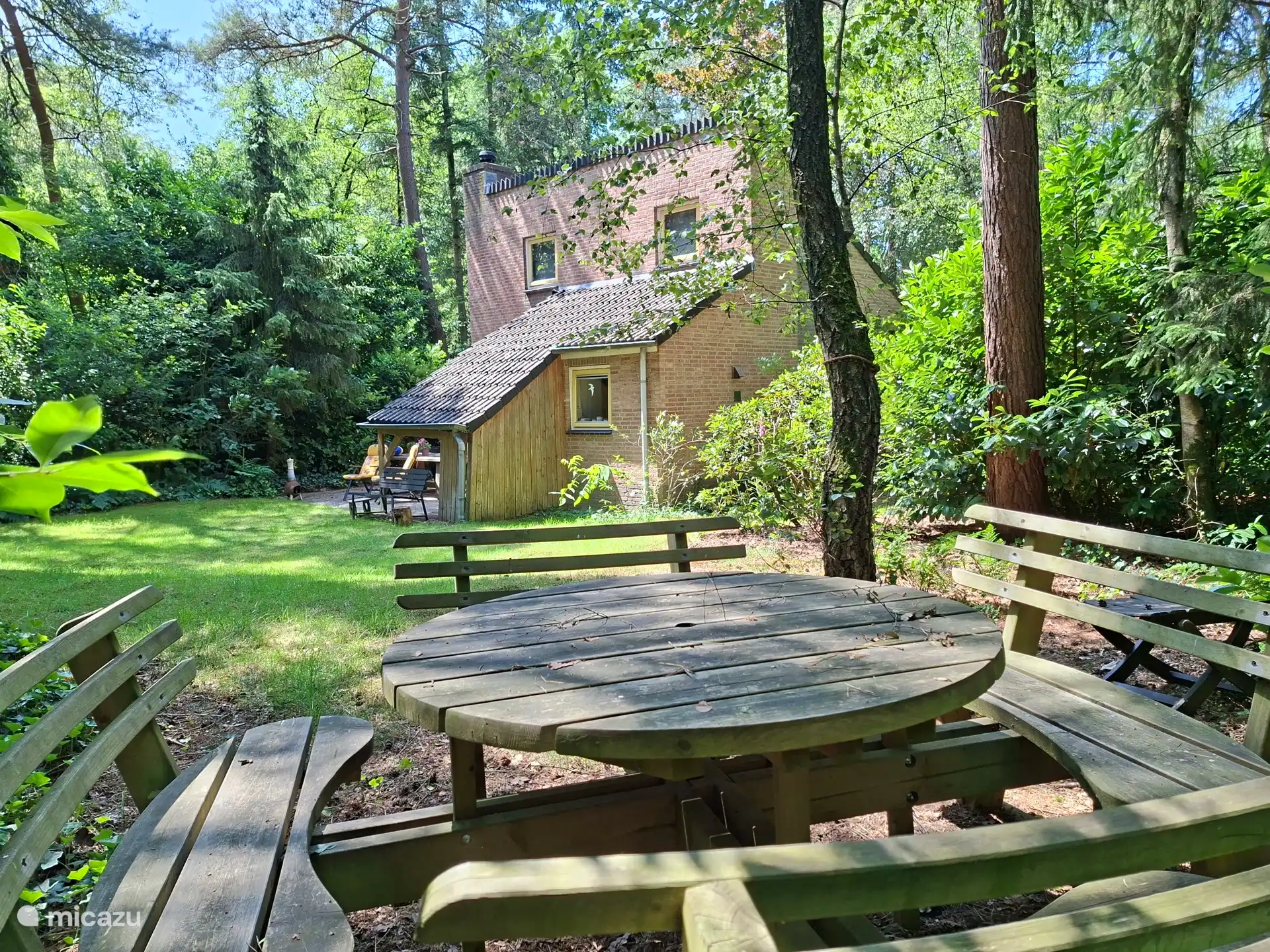 Schöner Garten, so und Schatten. Mehrere Sitzbereiche, darunter ein Picknicktisch, ein Gartentisch mit verstellbaren Stühlen/Stuhlkissen. Viel Privatsphäre und Grün