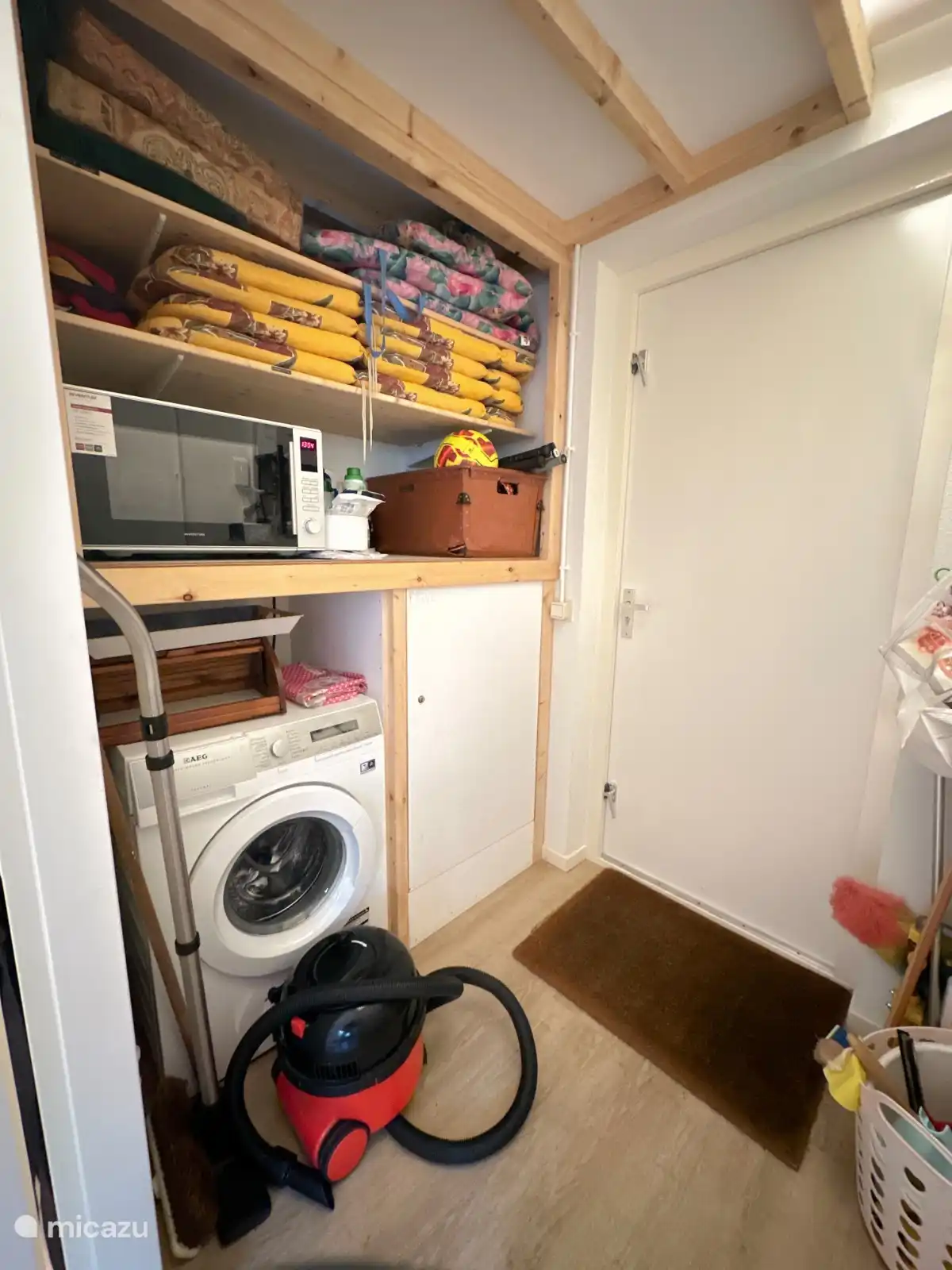 Der Abstellraum mit Kombi-Mikrowelle, Staubsauger. Stuhlkissen für die Gartenstühle. Die Waschmaschine mit Öko-Waschmittel. Tennisschläger und -bälle, Badmintonschläger mit Federbällen, Tischtennisbäder und -bälle