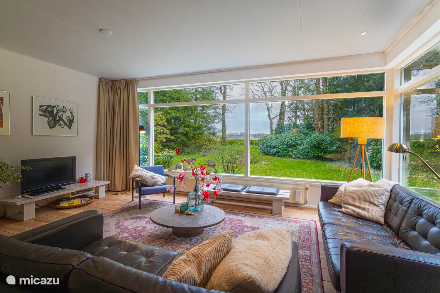 Das geräumige Wohnzimmer mit großen Fenstern mit Blick auf die Felder.