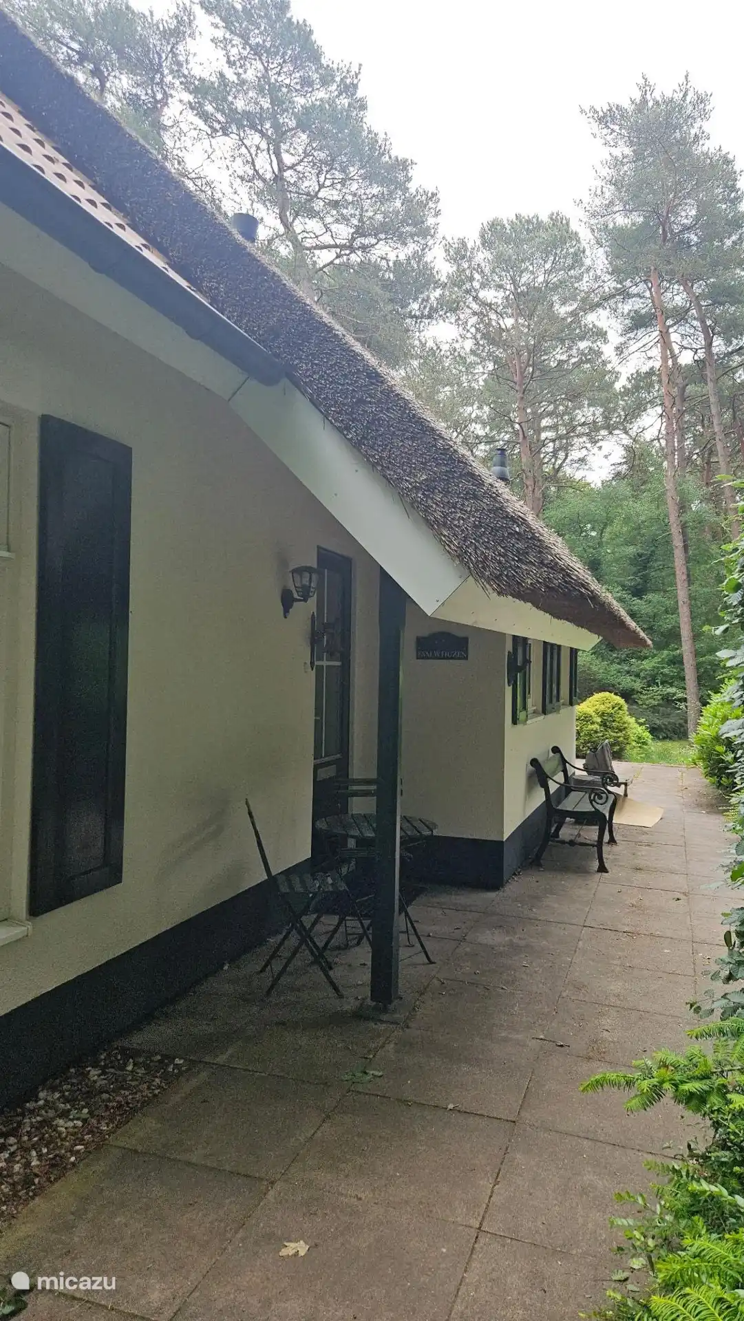 Ingang aan de zijkant van het huisje. Als je doorloopt kom je op het terras en de achtertuin. 