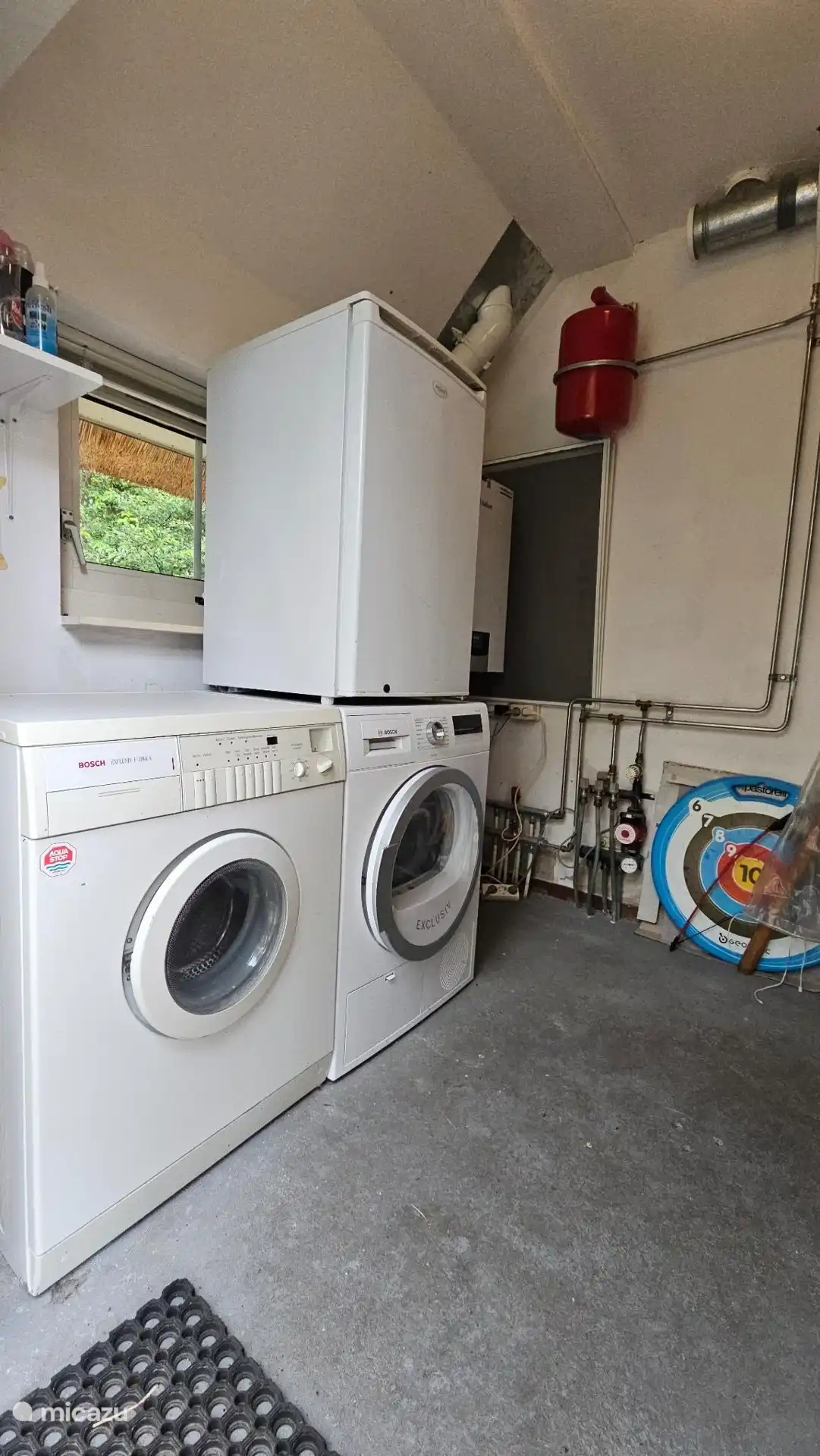 Bijkeuken met vriezer, wasmachine en droger.