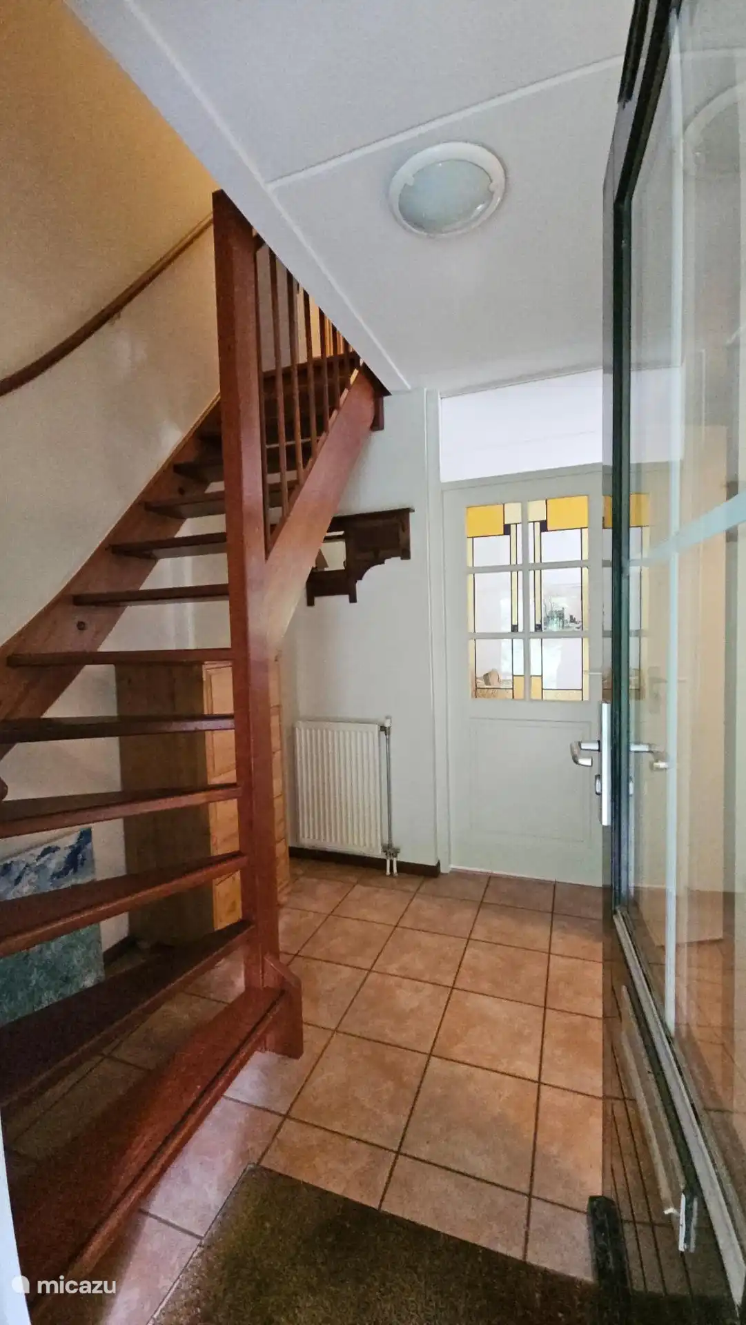 De hal met deuren naar de woonkamer, toilet en badkamer. De trap gaat naar de twee slaapkamer en bedstee. 